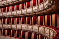 Tiers of gilded theatre boxes hung with red velvet curtains