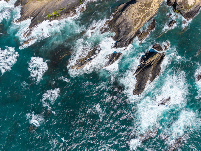 Waves crashing on rocky coastline from above
