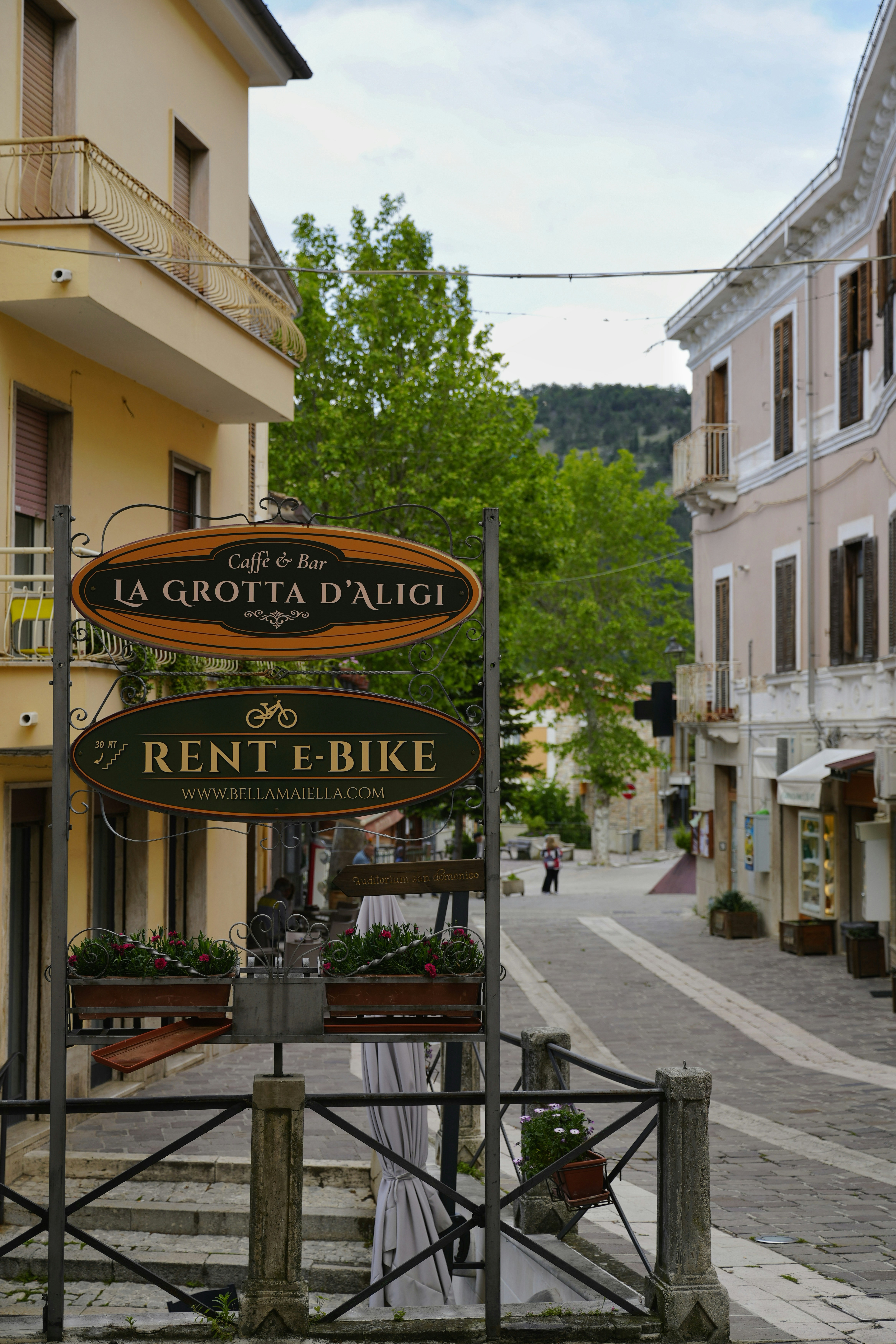 Street signs for cafe and bike rental in a town