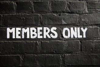 Members only sign on a brick wall