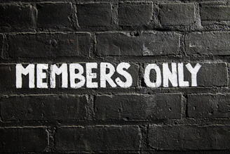 Members only sign on a brick wall