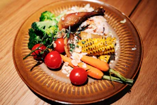 Roasted chicken with rice and fresh vegetables on a plate
