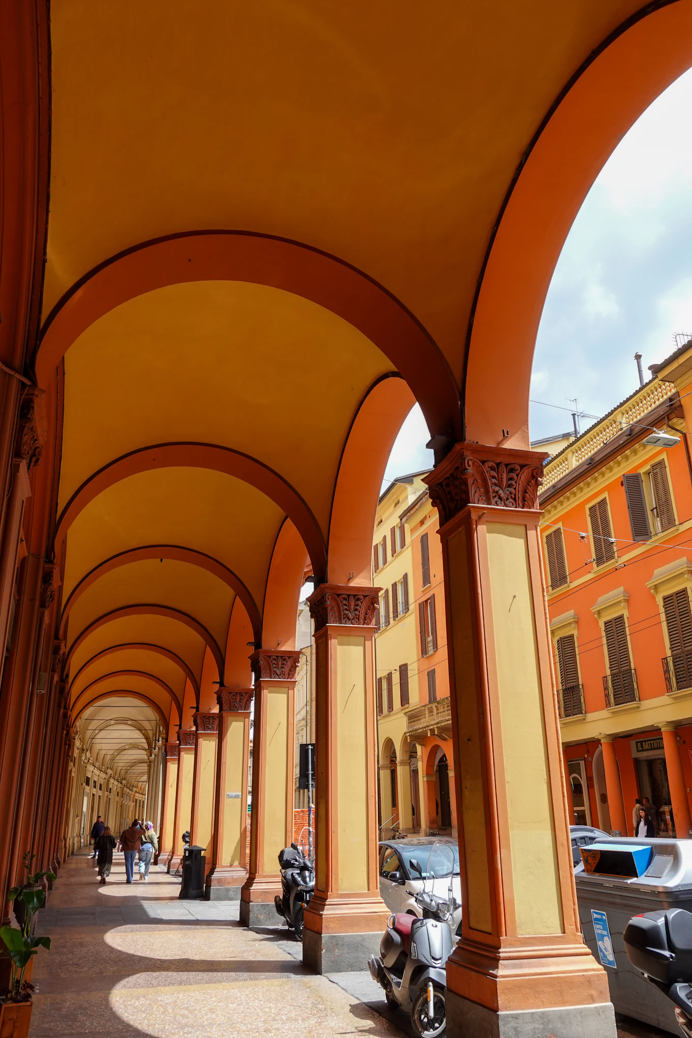 A Bolognese portico at midday, ochre plaster and low arches