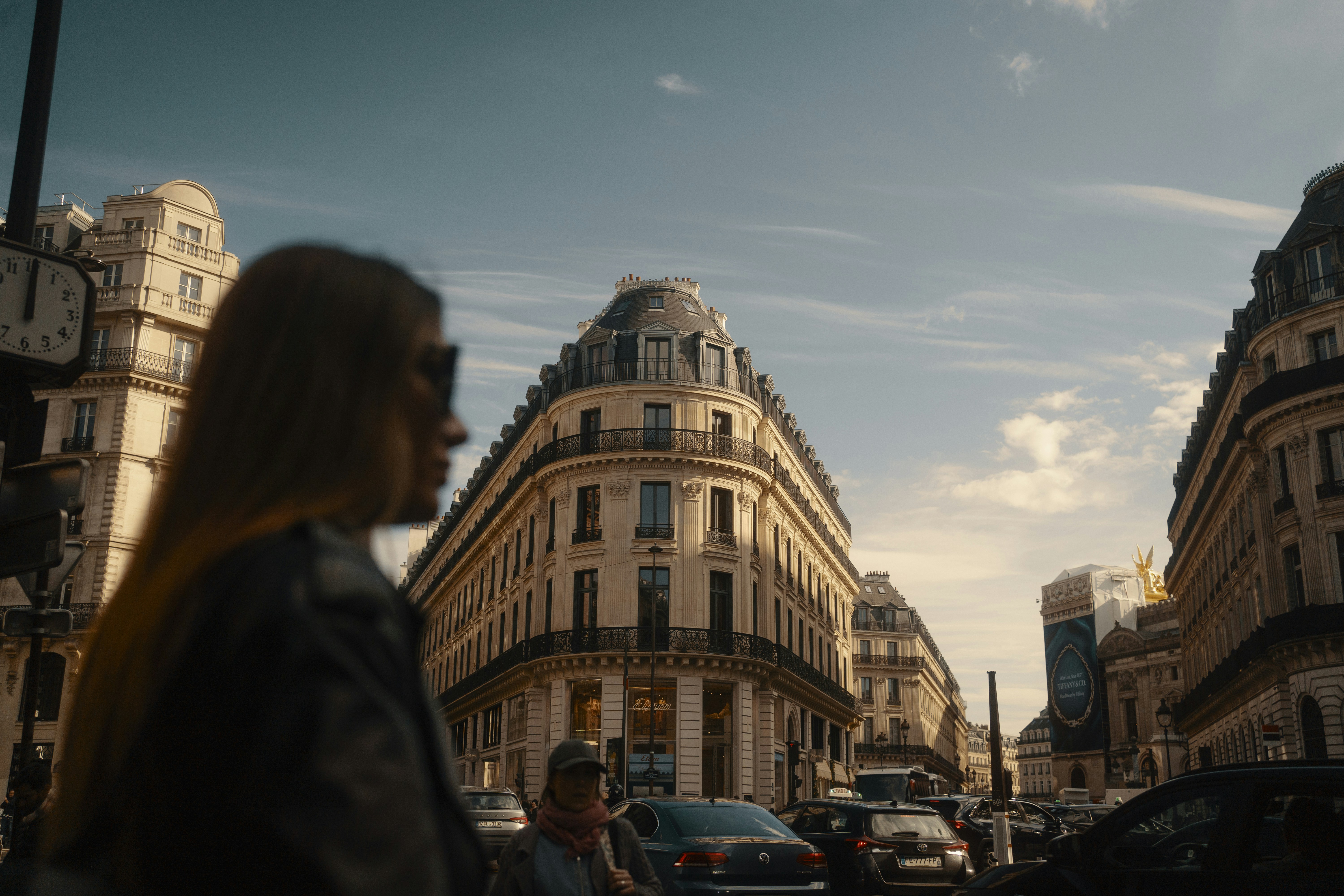 Woman walking on a parisian street with buildings.