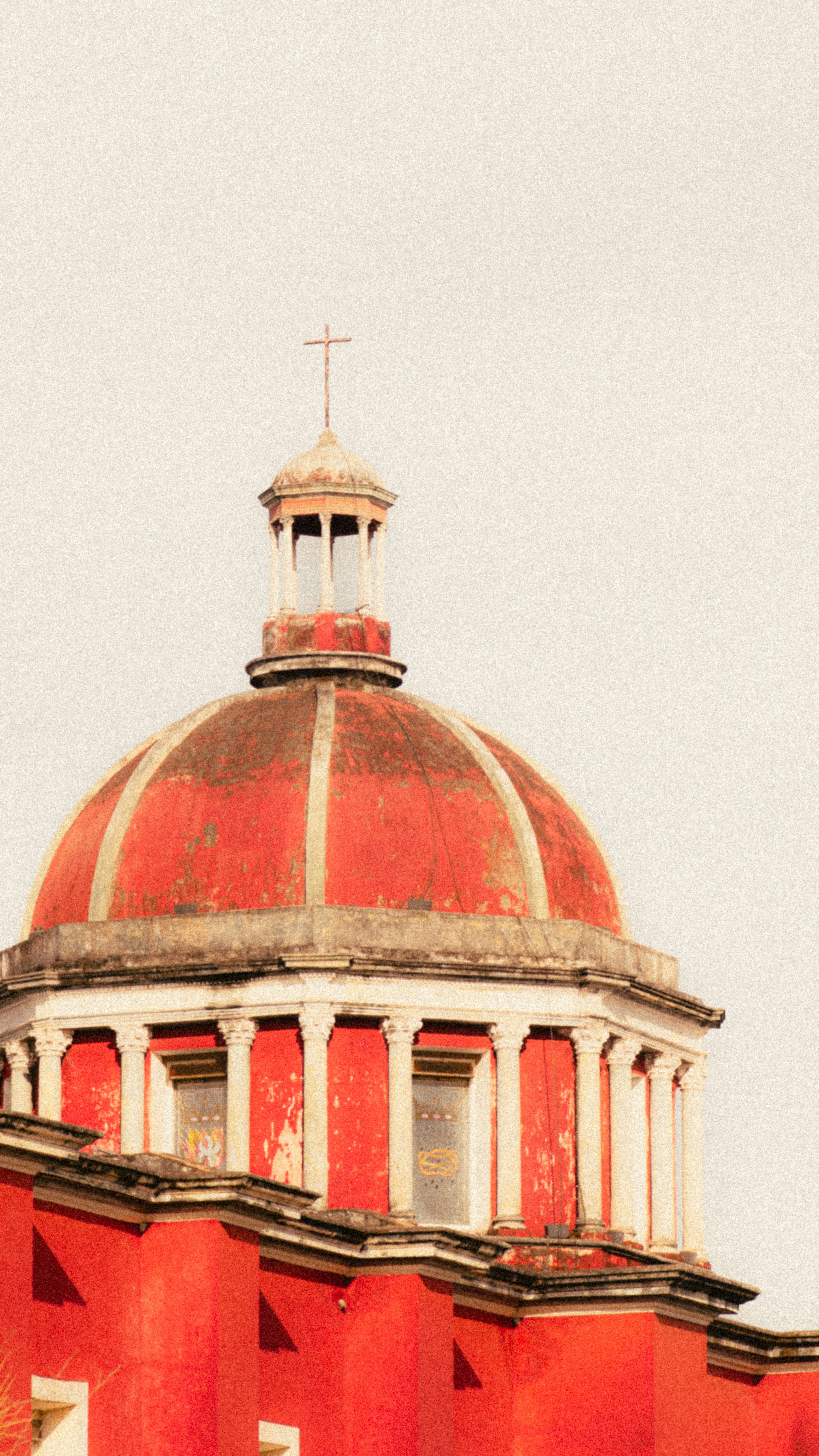 Red dome with white columns and a cross