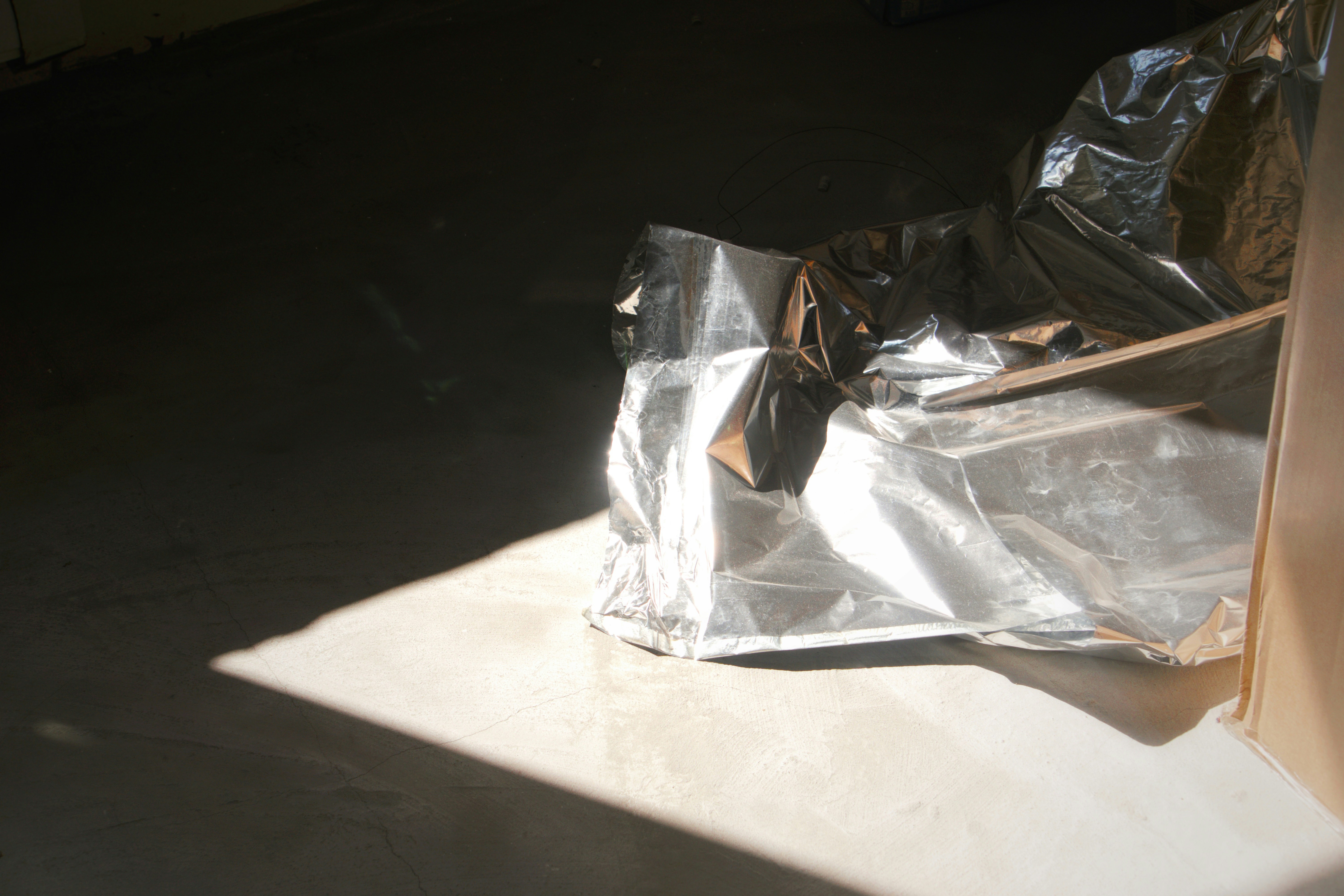 Shiny metallic packaging on a concrete floor.