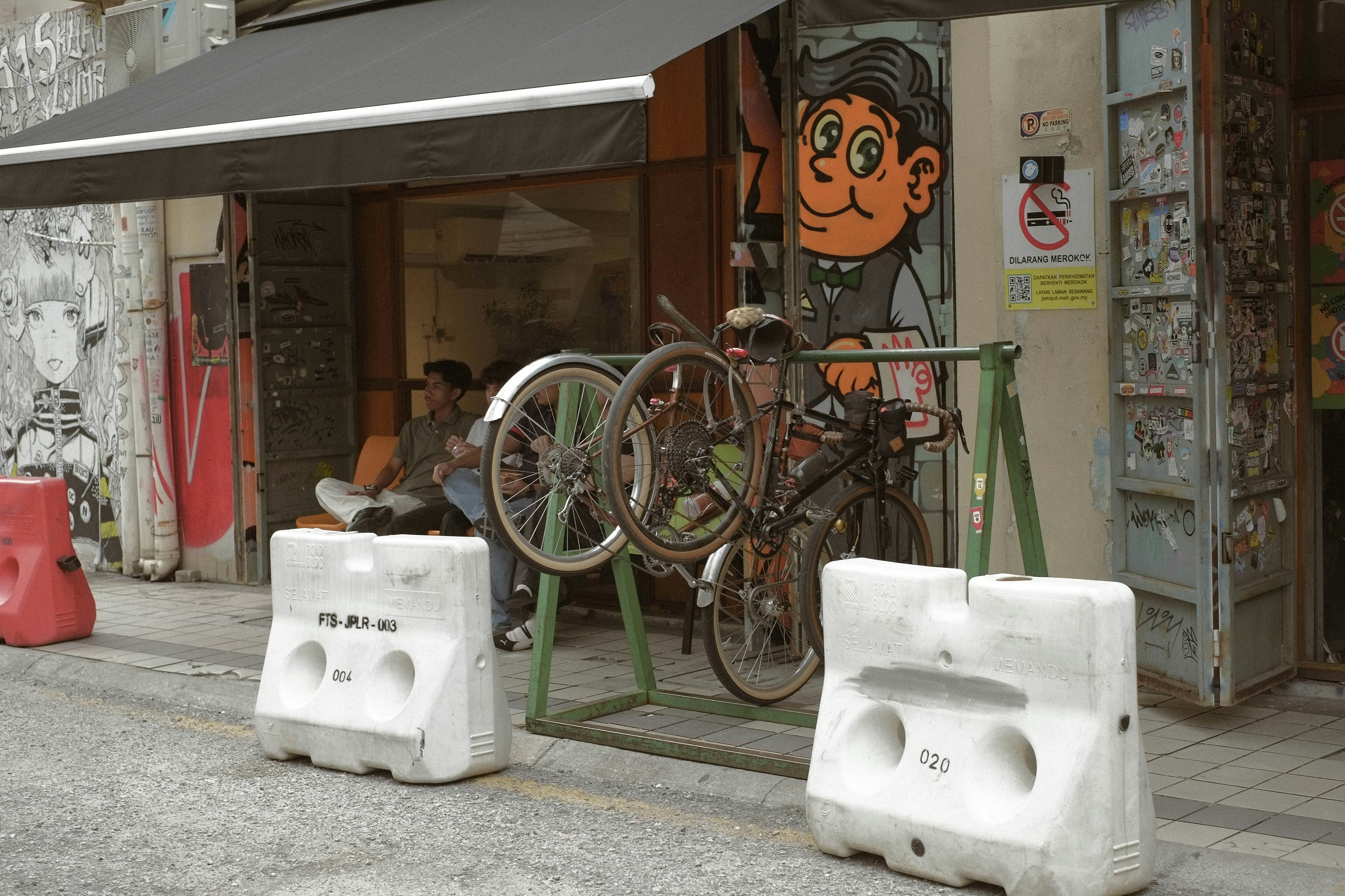Bicycle parked outside a shop with graffiti art on wall