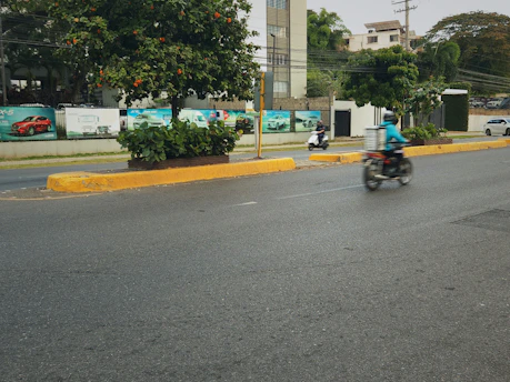 Motorcyclist rides down a wet city street.