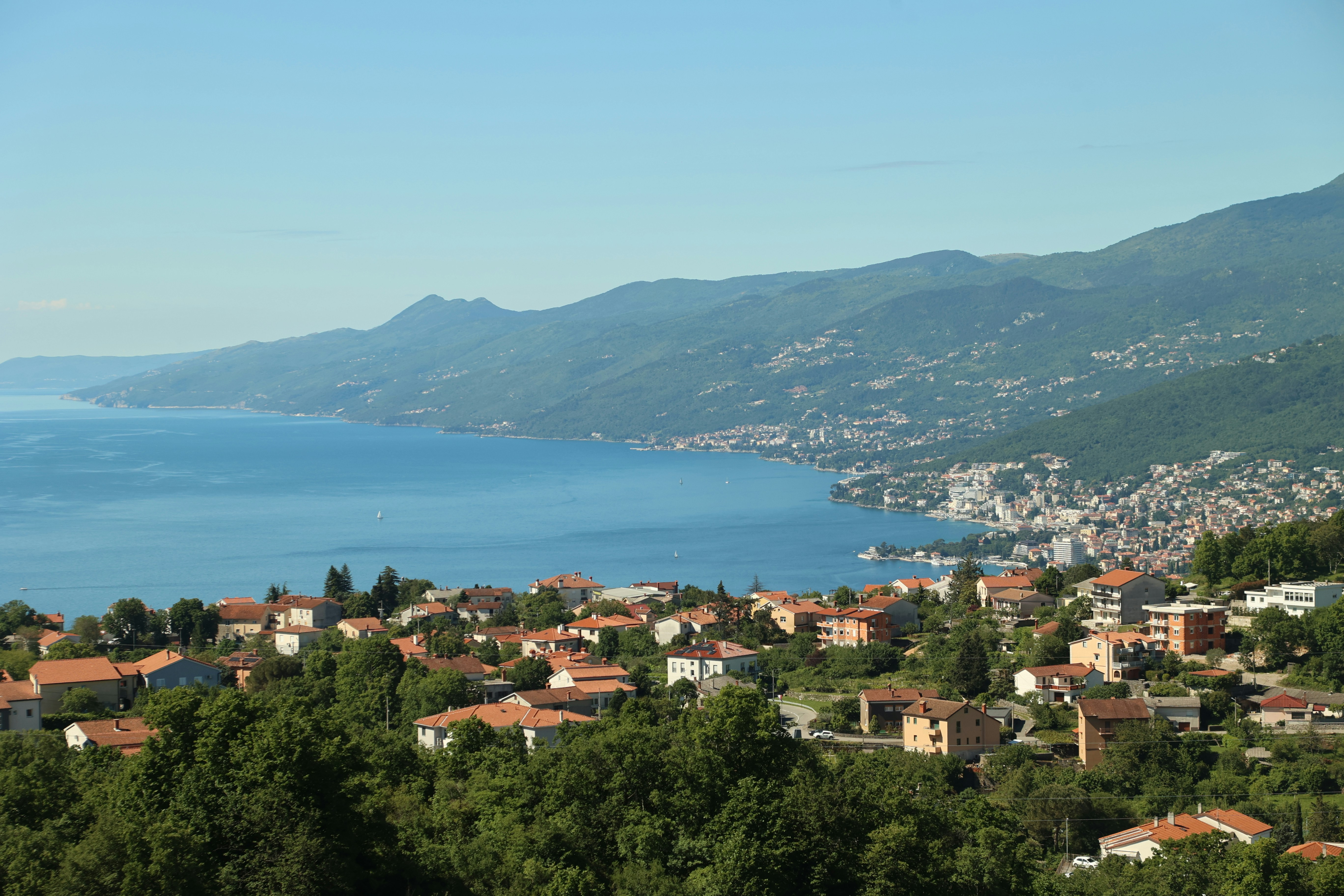 Küstenstadt, eingebettet an eine blaue Bucht und Berge.
