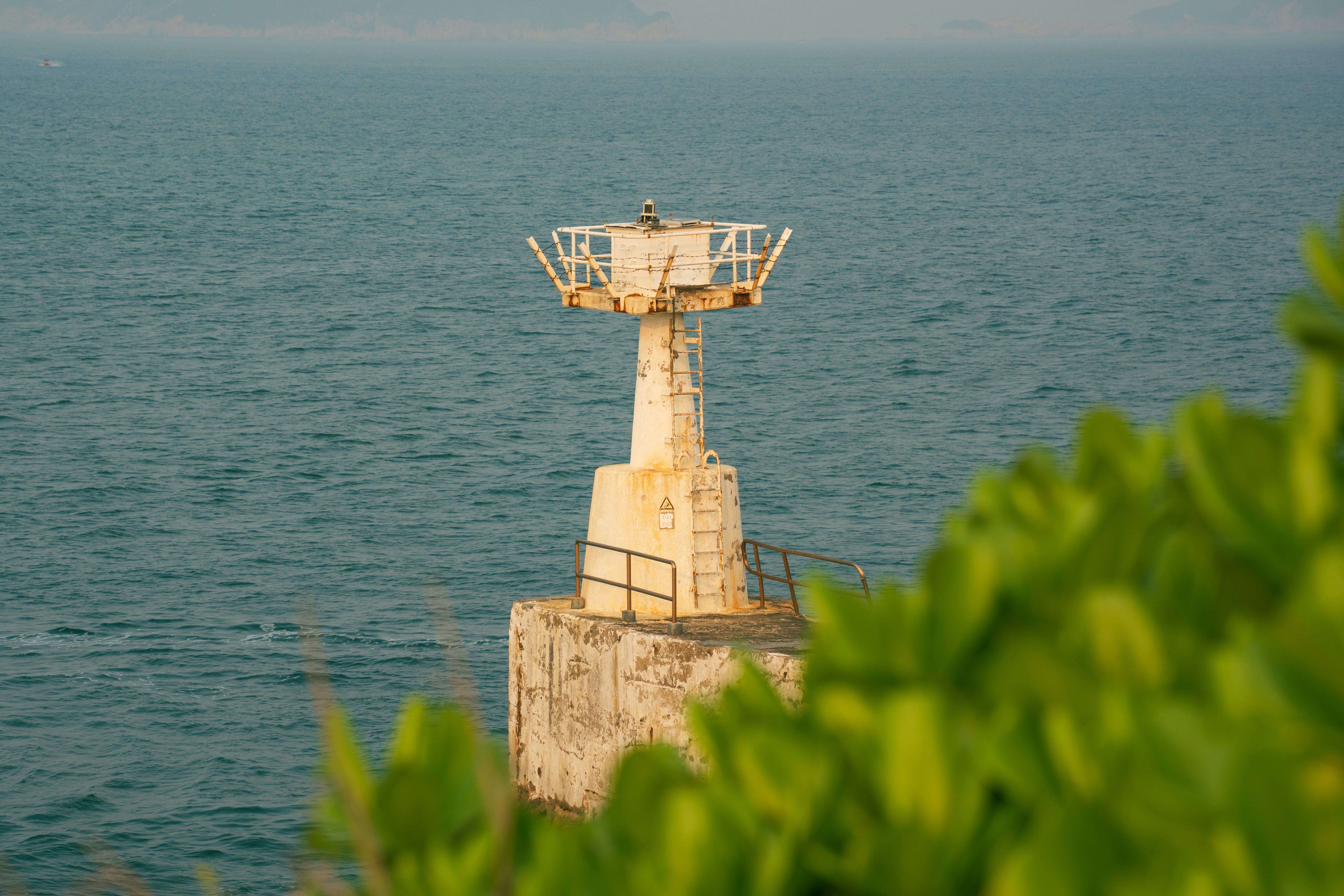 A lighthouse stands on a rocky coast overlooking the ocean.