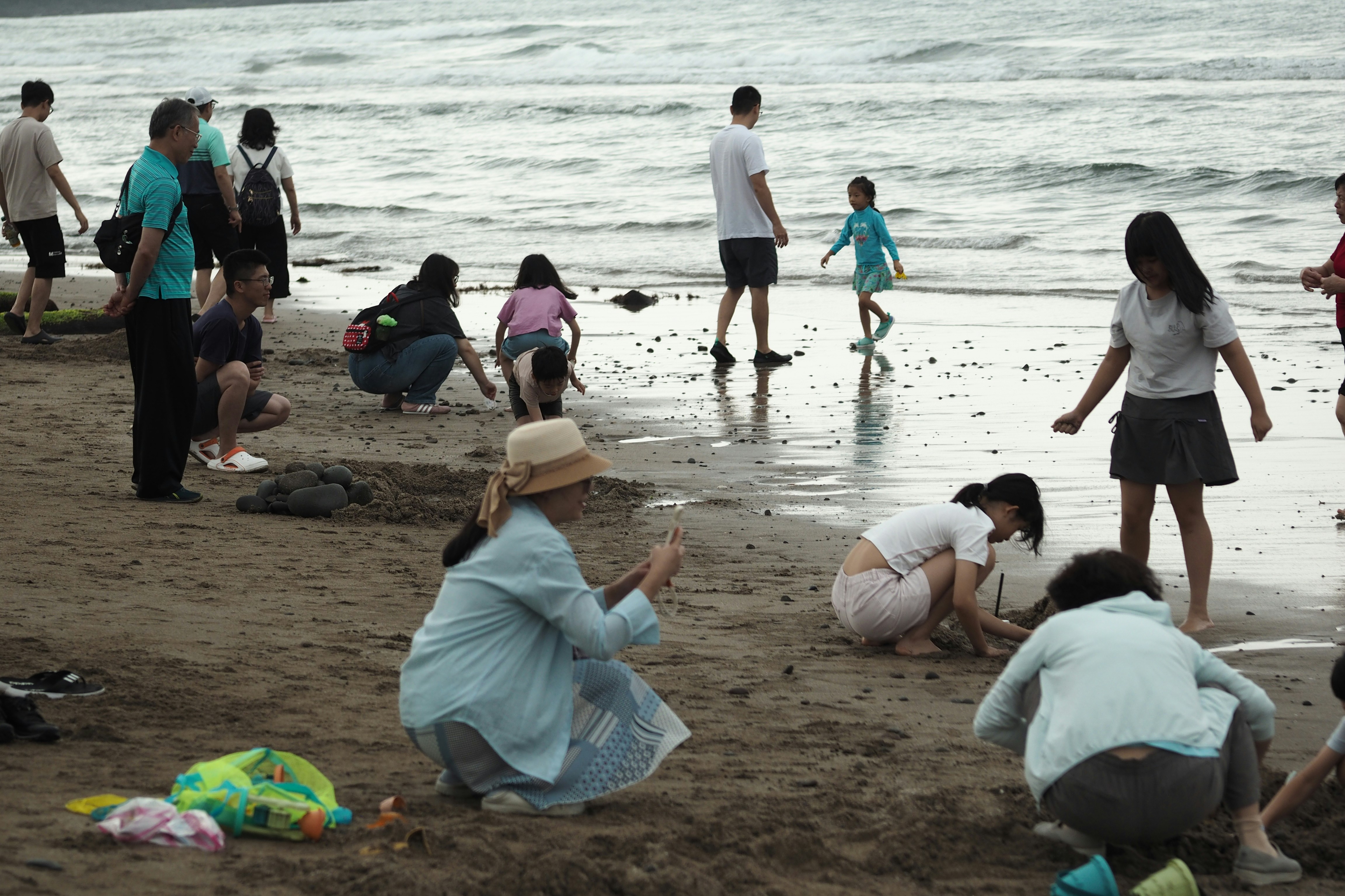 Orang-orang bermain di pantai berpasir dekat air