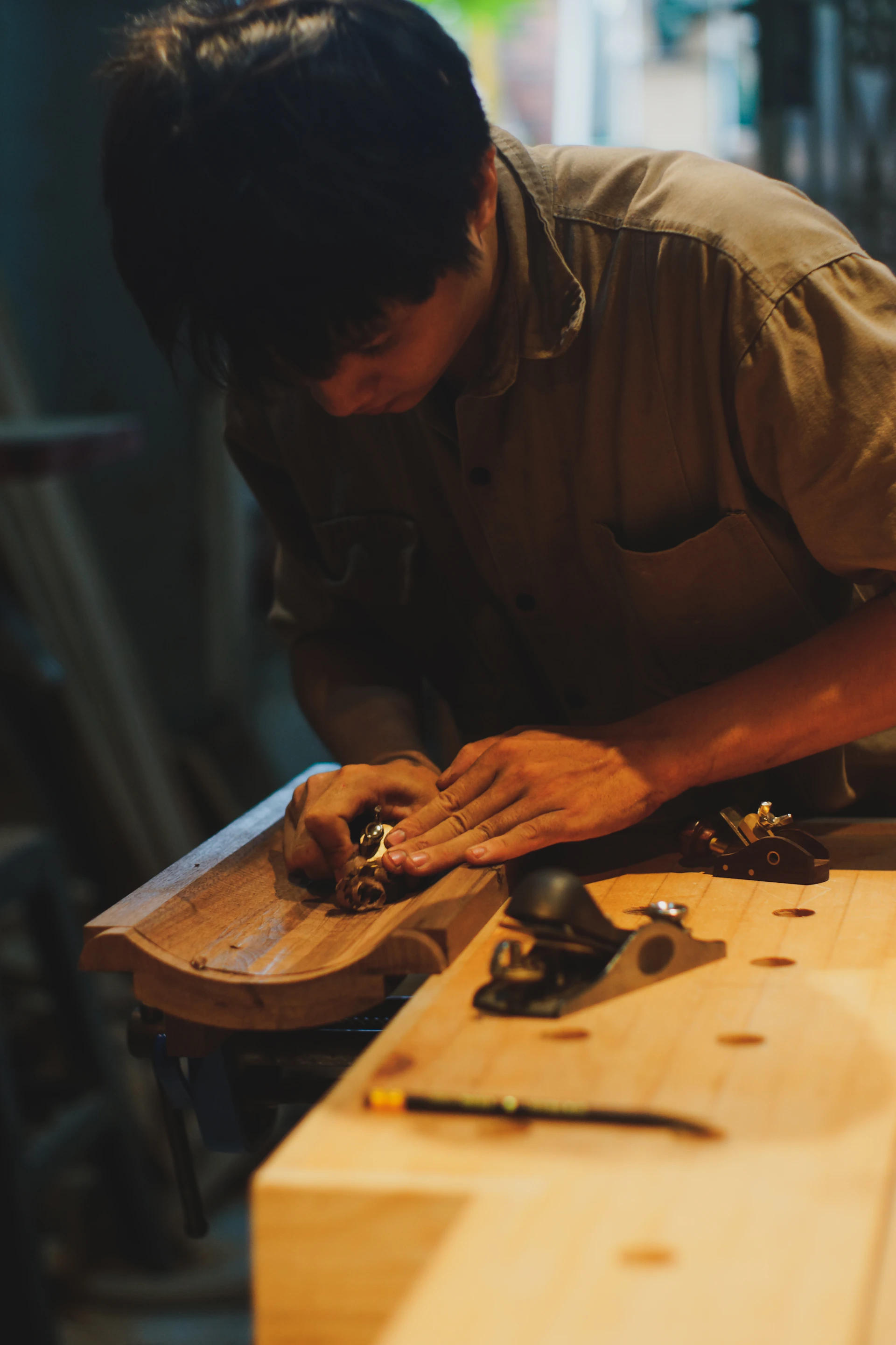 Craftsman sanding a wooden object with tools