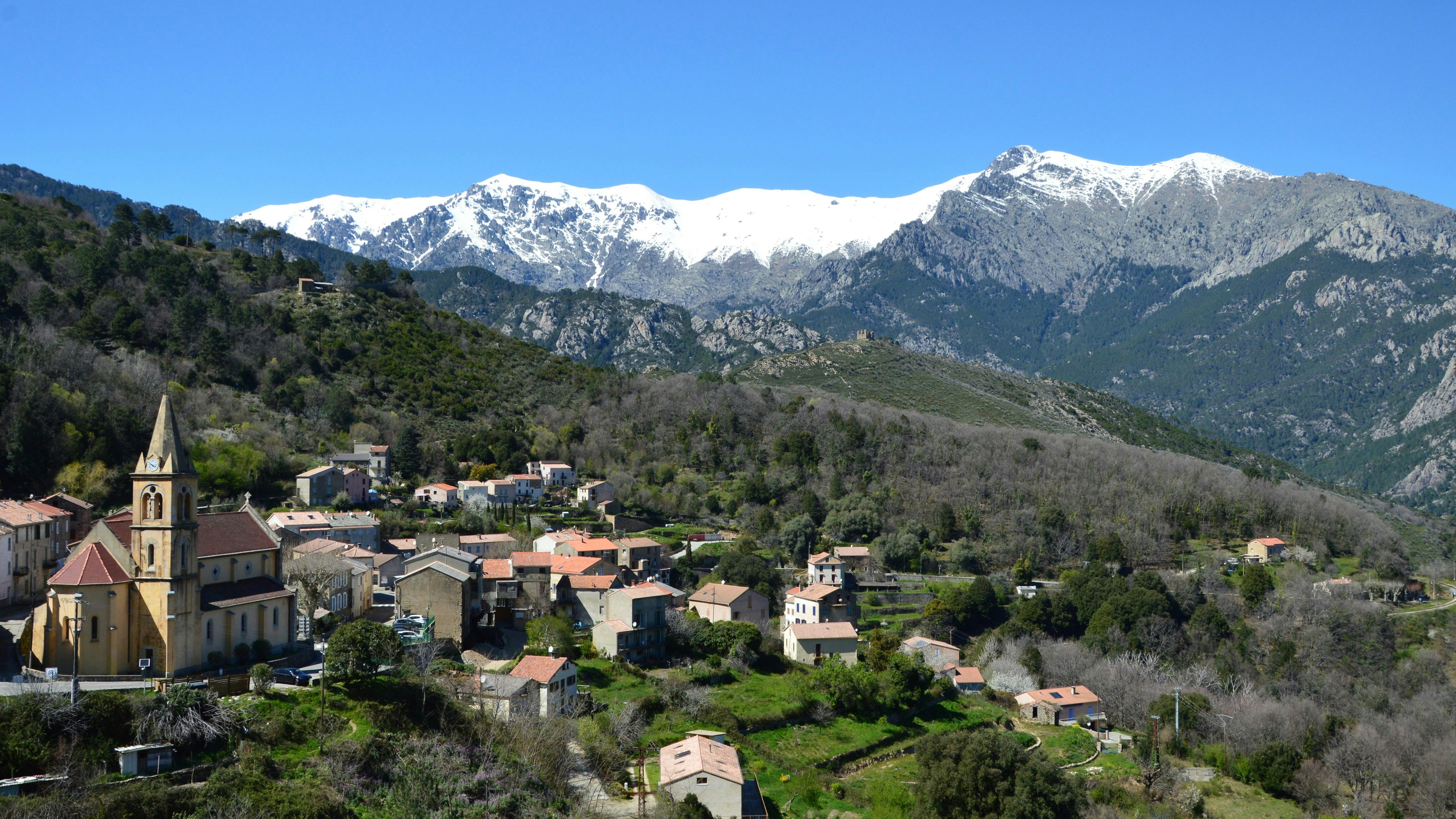 Un villaggio pittoresco immerso in una valle con montagne innevate.