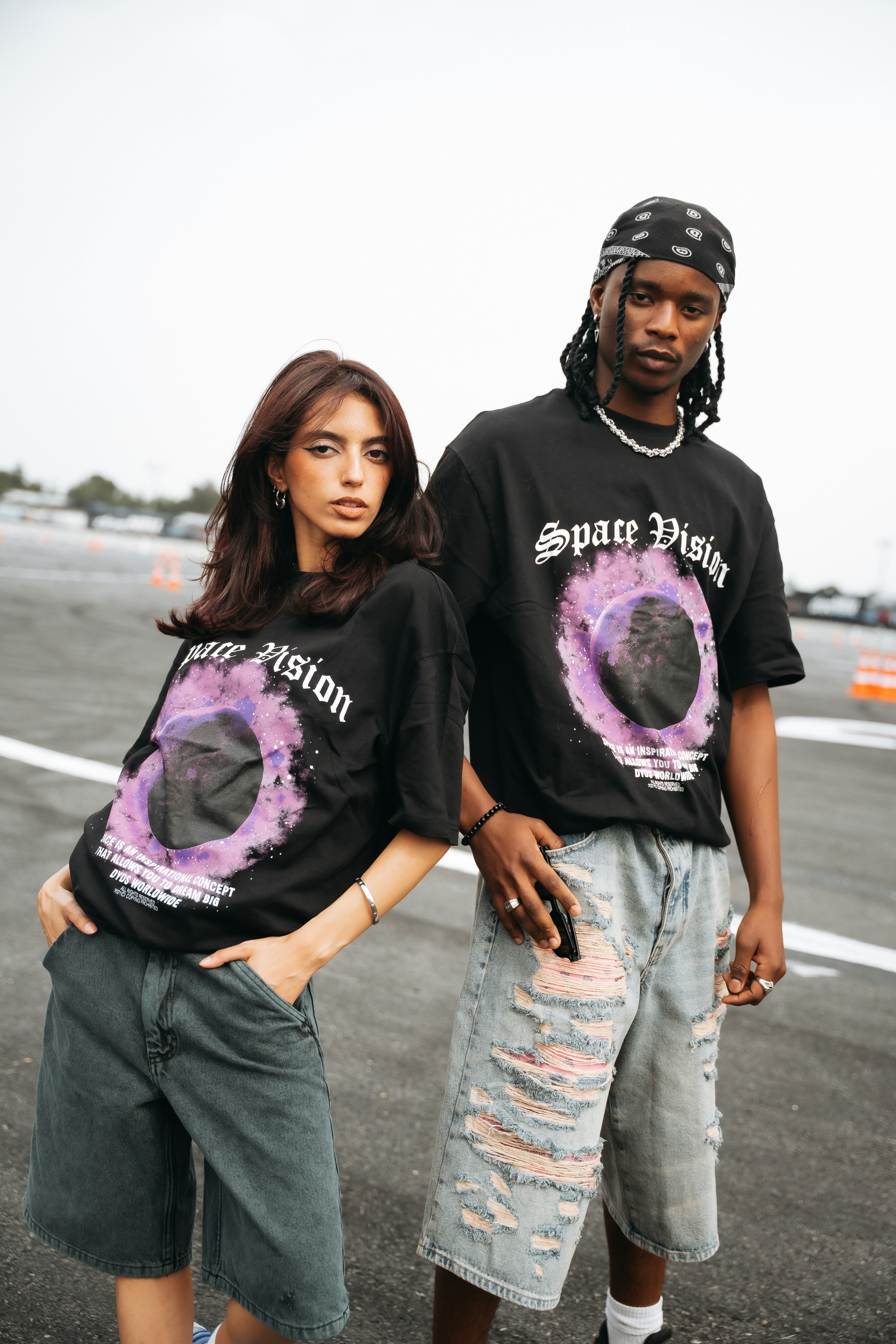 Dos modelos con camisetas negras con estampado morado