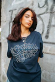 Young woman in a dark t-shirt with graphic print.