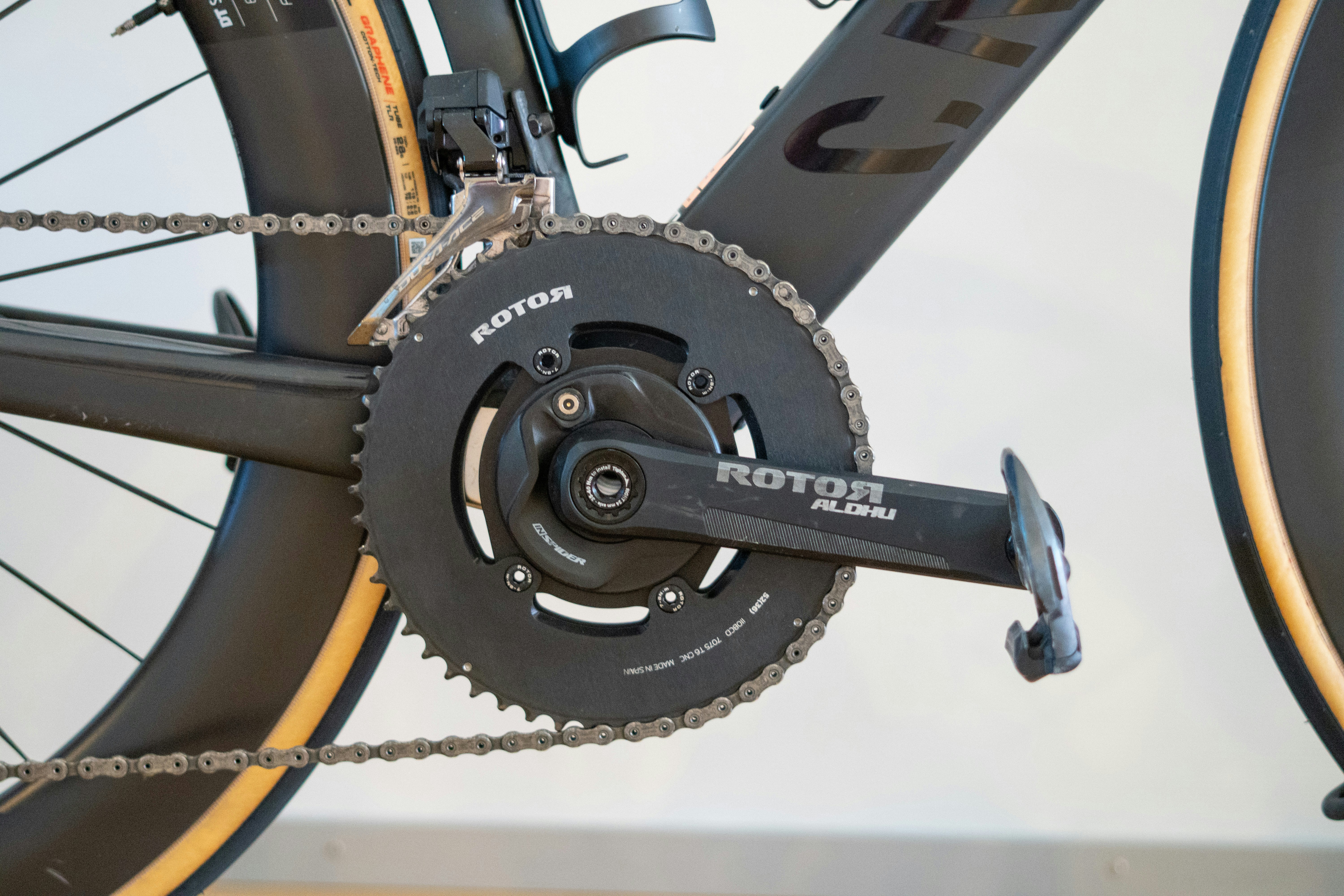Modern bicycle's black rotor chainring and crankset with chain.