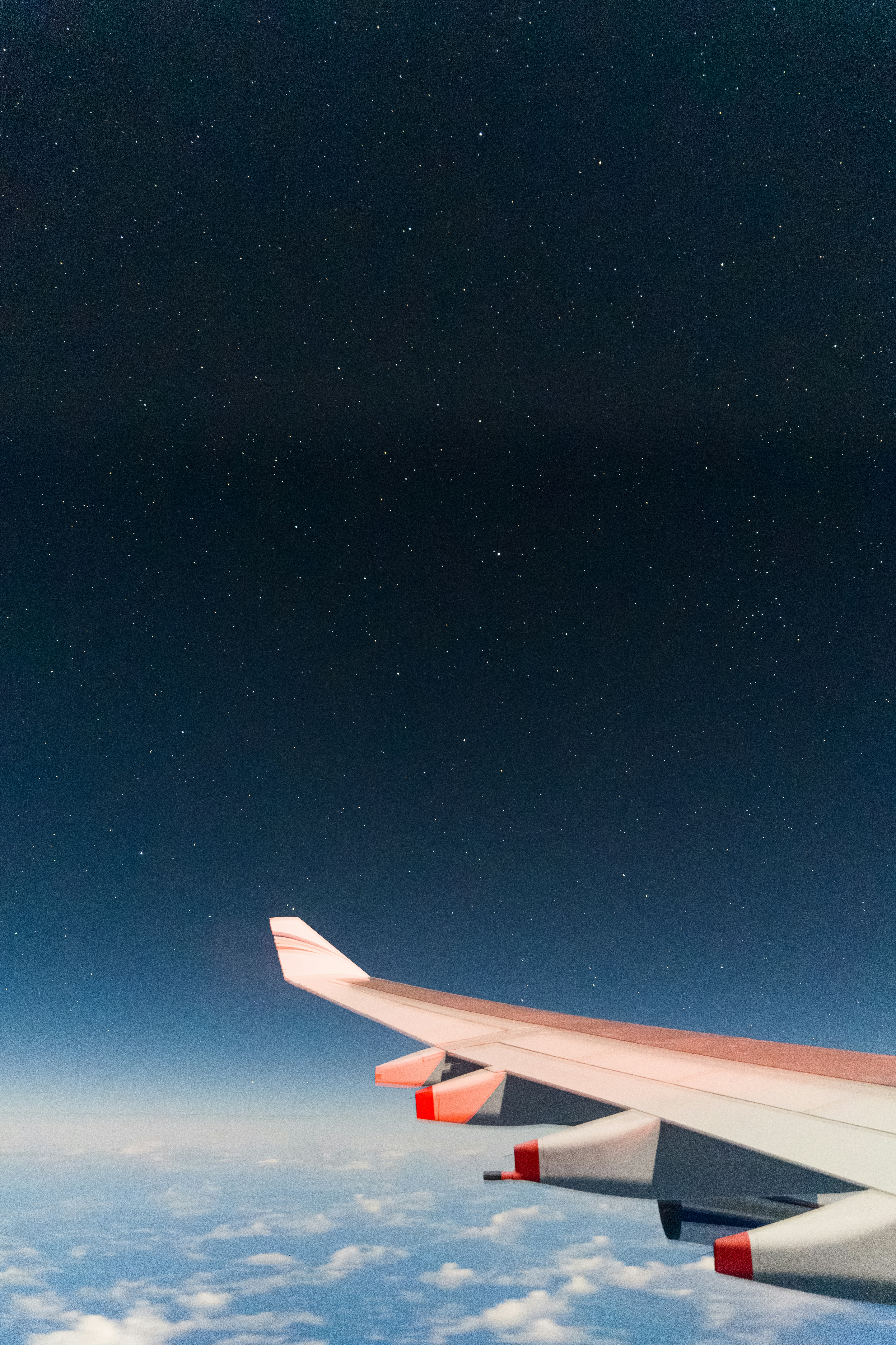 Airplane wing against a starry night sky.