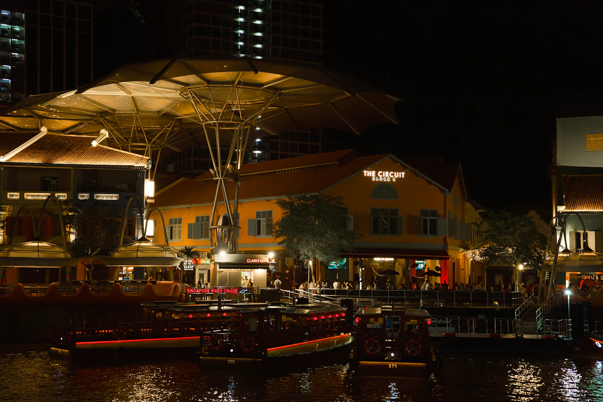 Vibrant nightlife, outdoor dining terraces, and colourful lit-up buildings along the Clarke Quay river promenade