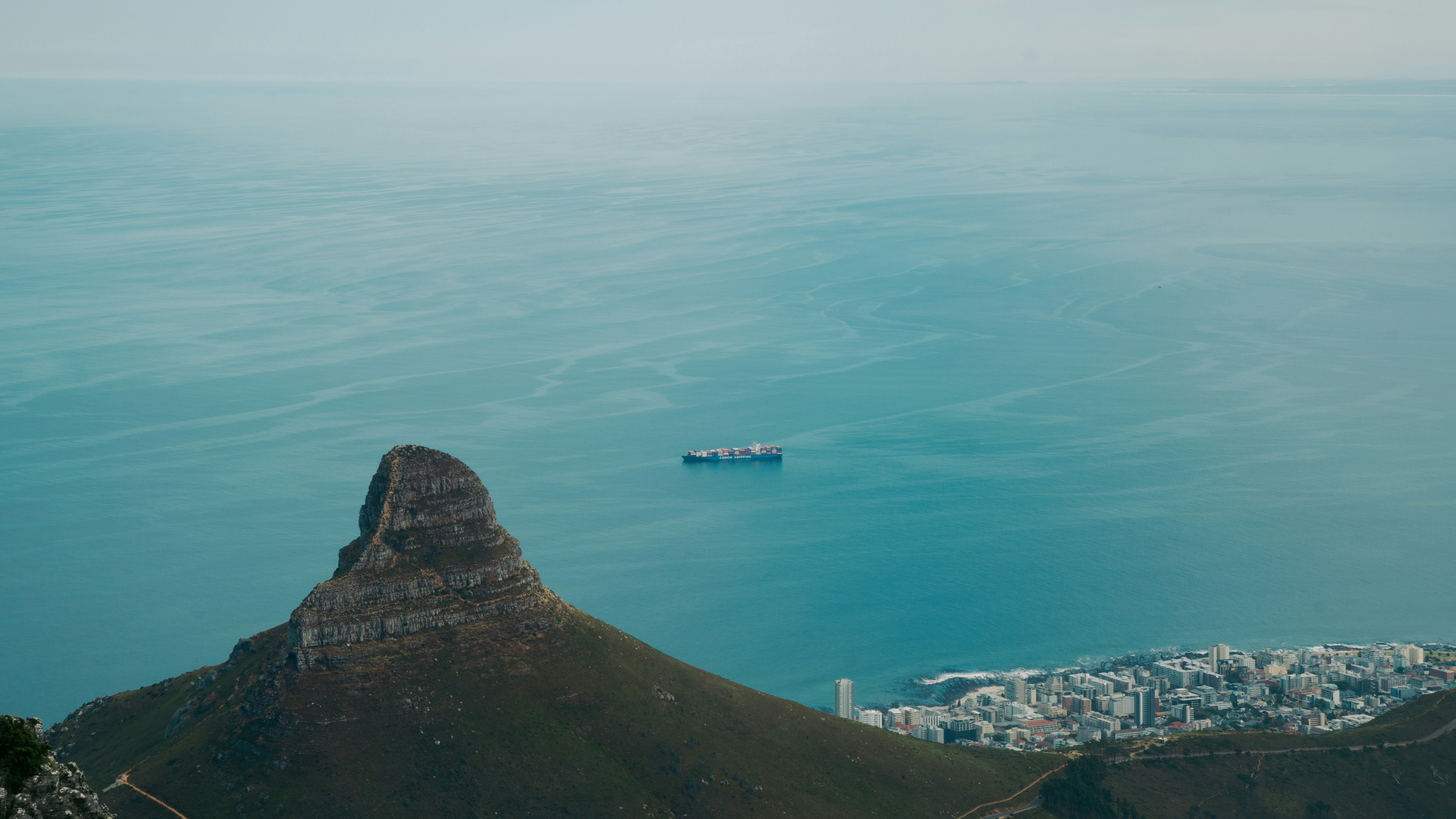 Coastal view with ship, mountain, and city