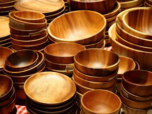 Many wooden bowls and plates are stacked together.