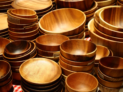 Many wooden bowls and plates are stacked together.
