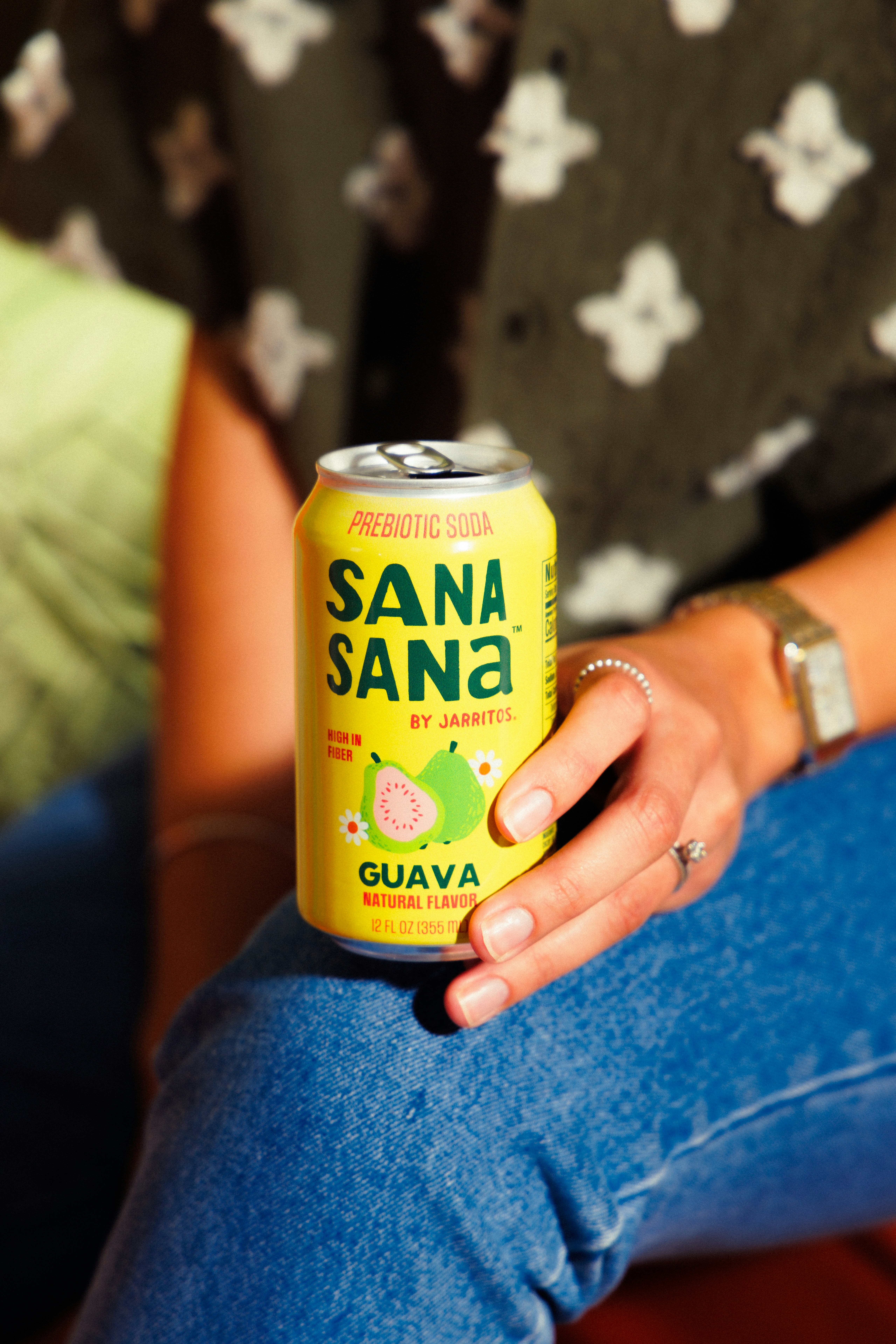 Persona sosteniendo una lata amarilla de refresco sana sana guayaba.