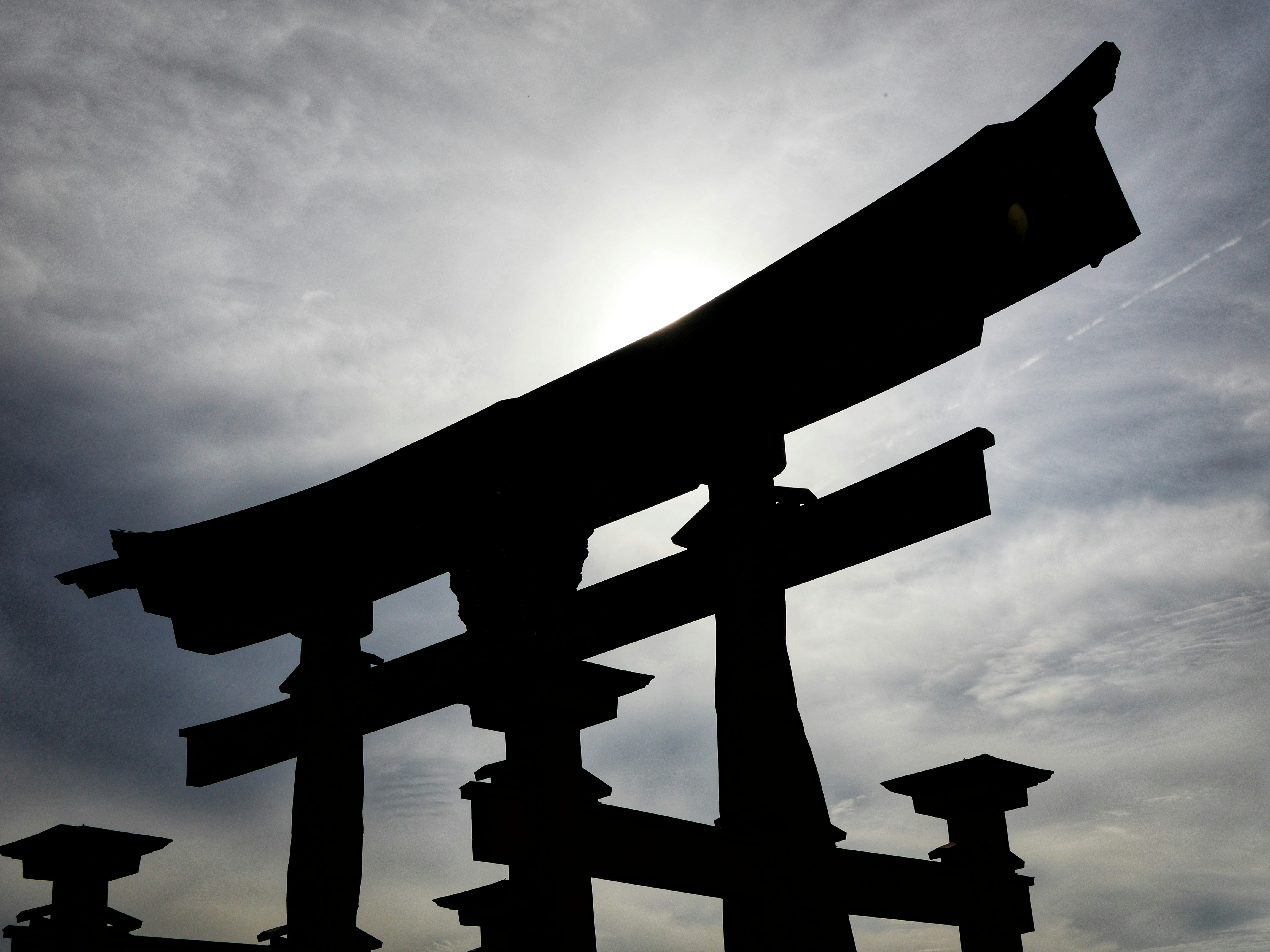 Silueta de una puerta torii japonesa contra cielo nublado