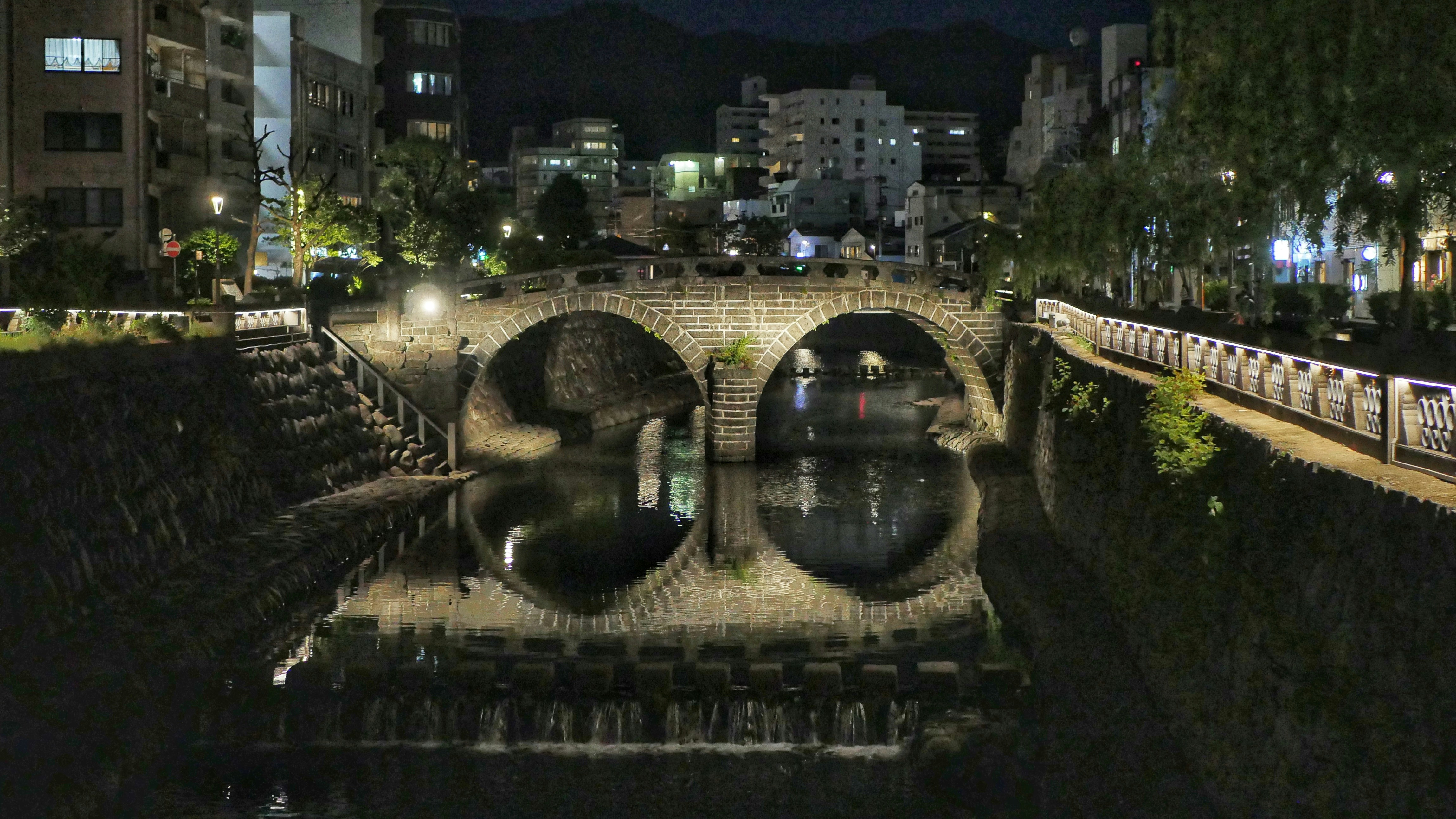 Puente de piedra con arcos sobre un canal por la noche