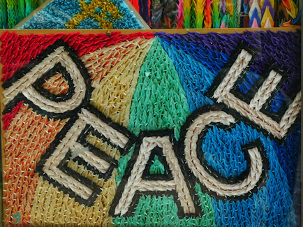 Colorful woven art spelling out the word peace
