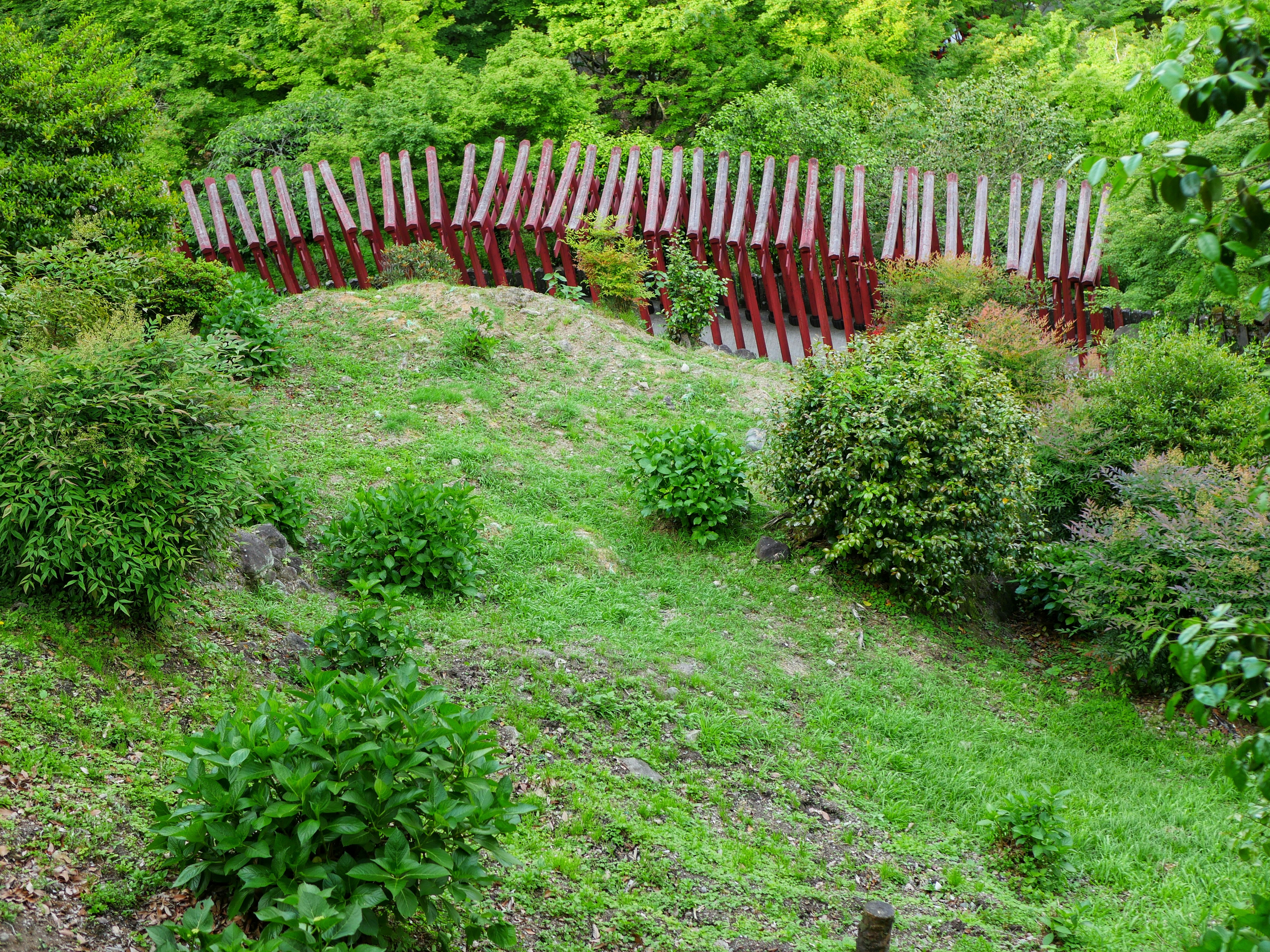 Instalación escultórica en un jardín verde y frondoso