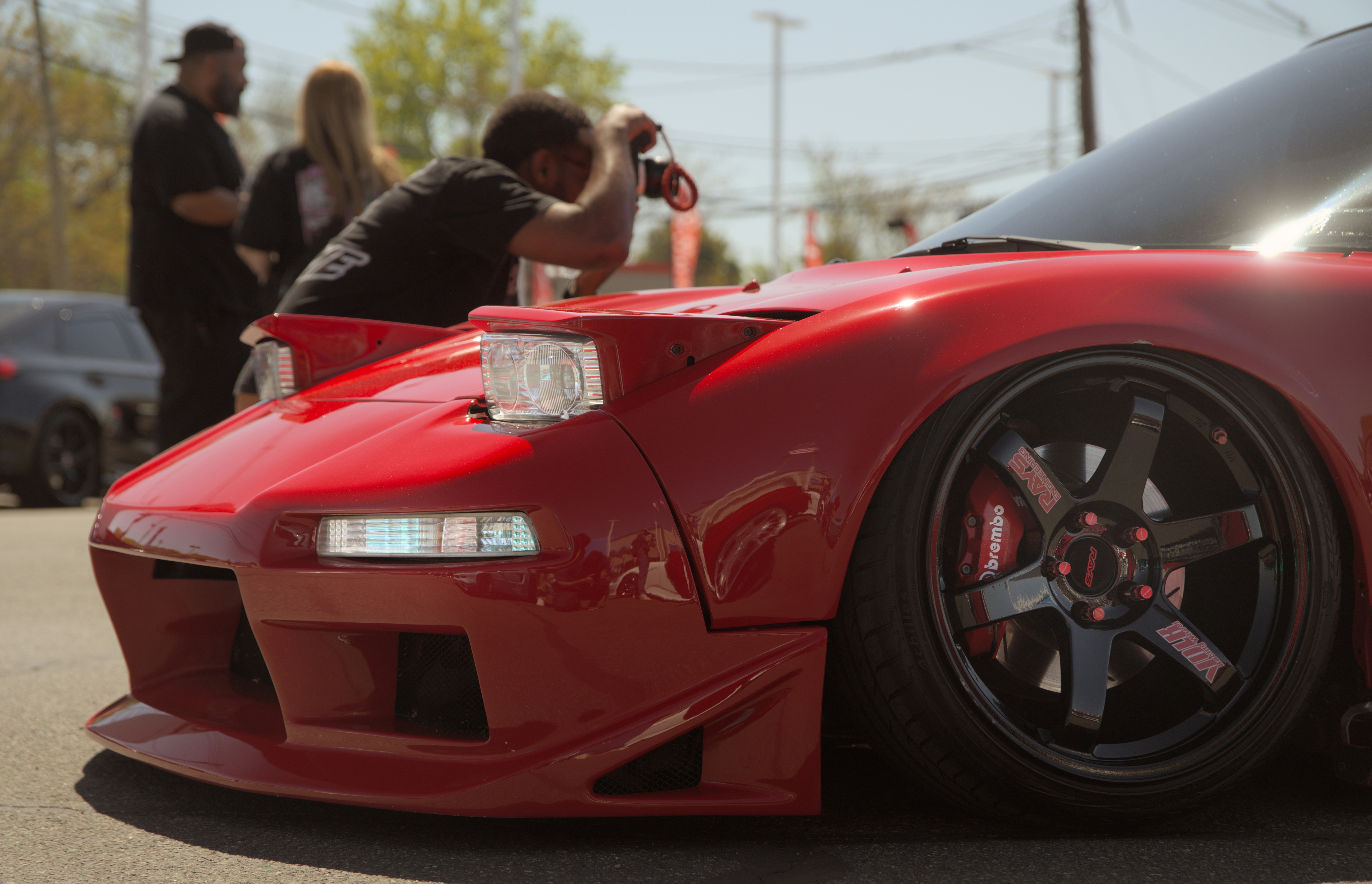Seseorang memotret mobil sport merah dengan lampu depan pop-up.