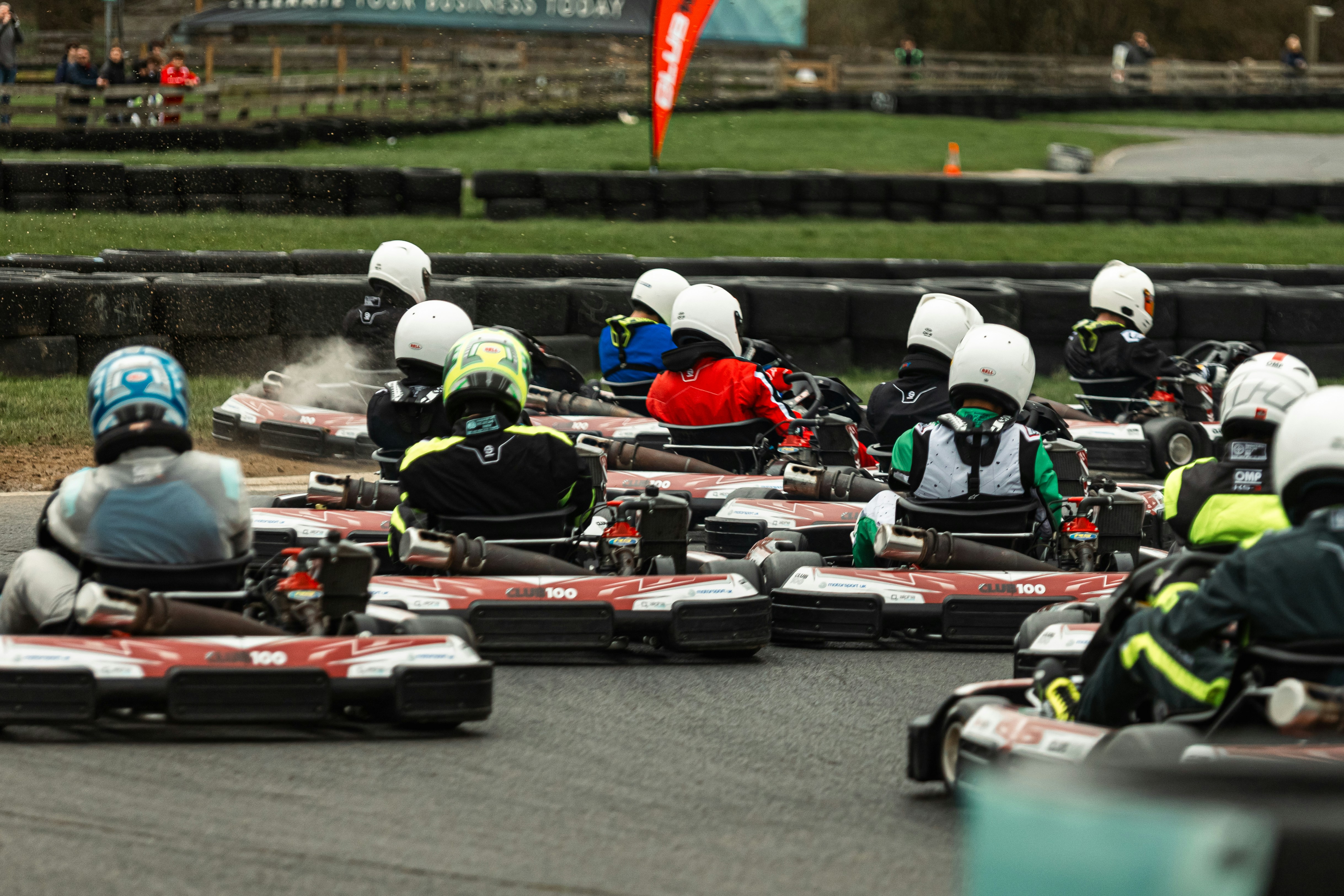 Sekelompok go-kart berlomba di trek luar ruangan.