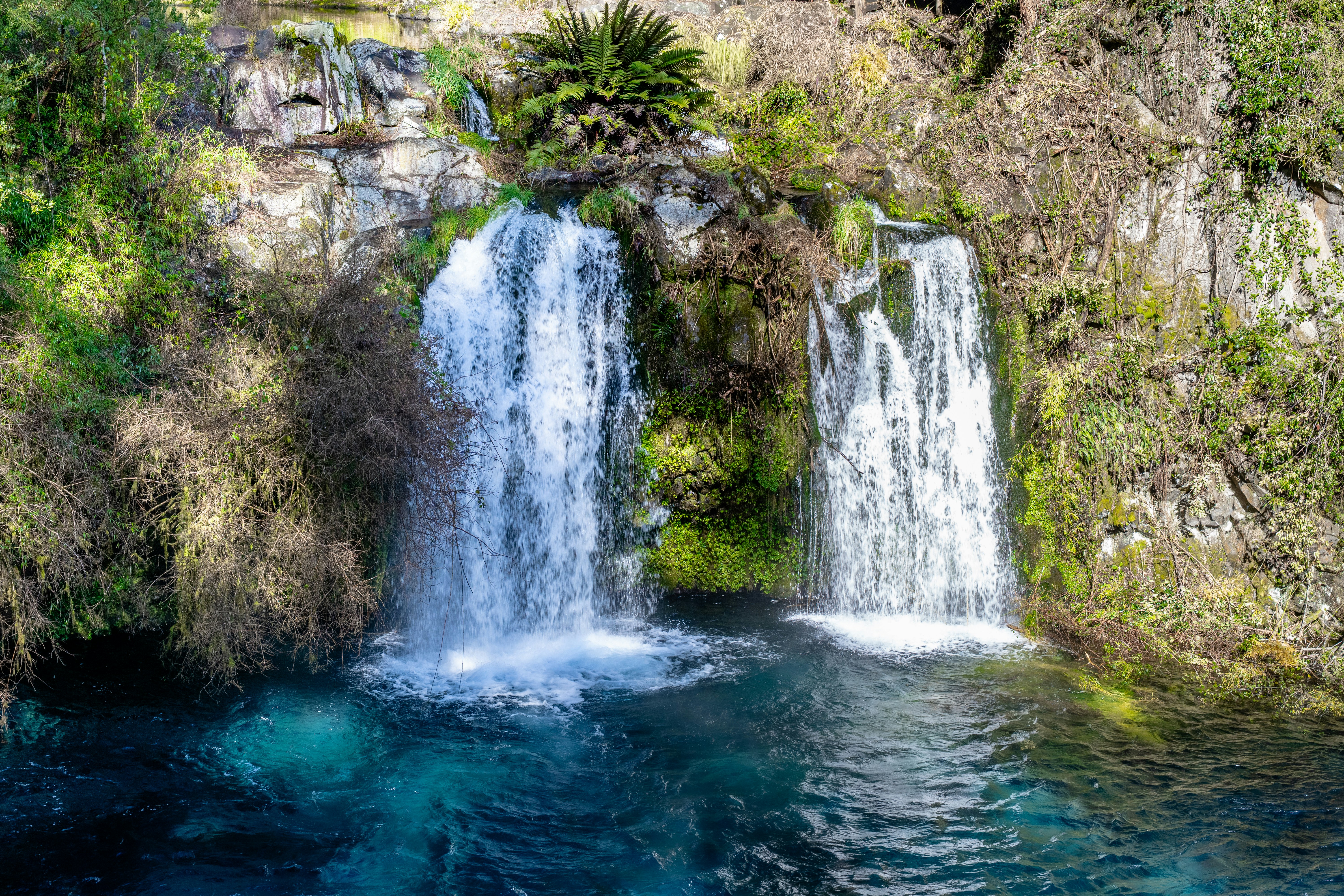 Dos cascadas desembocan en una piscina azul clara.