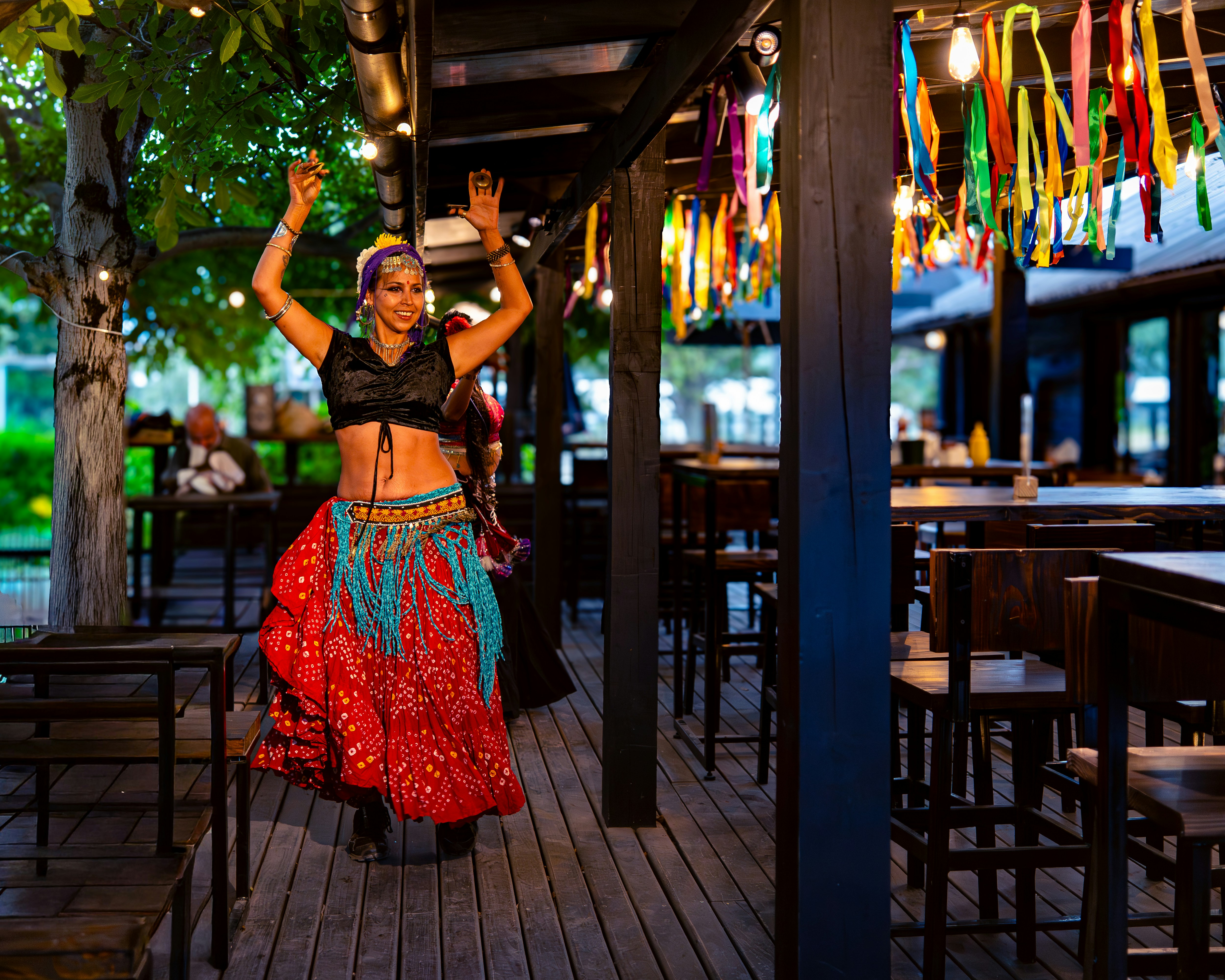 Una mujer con ropa colorida baila al aire libre.