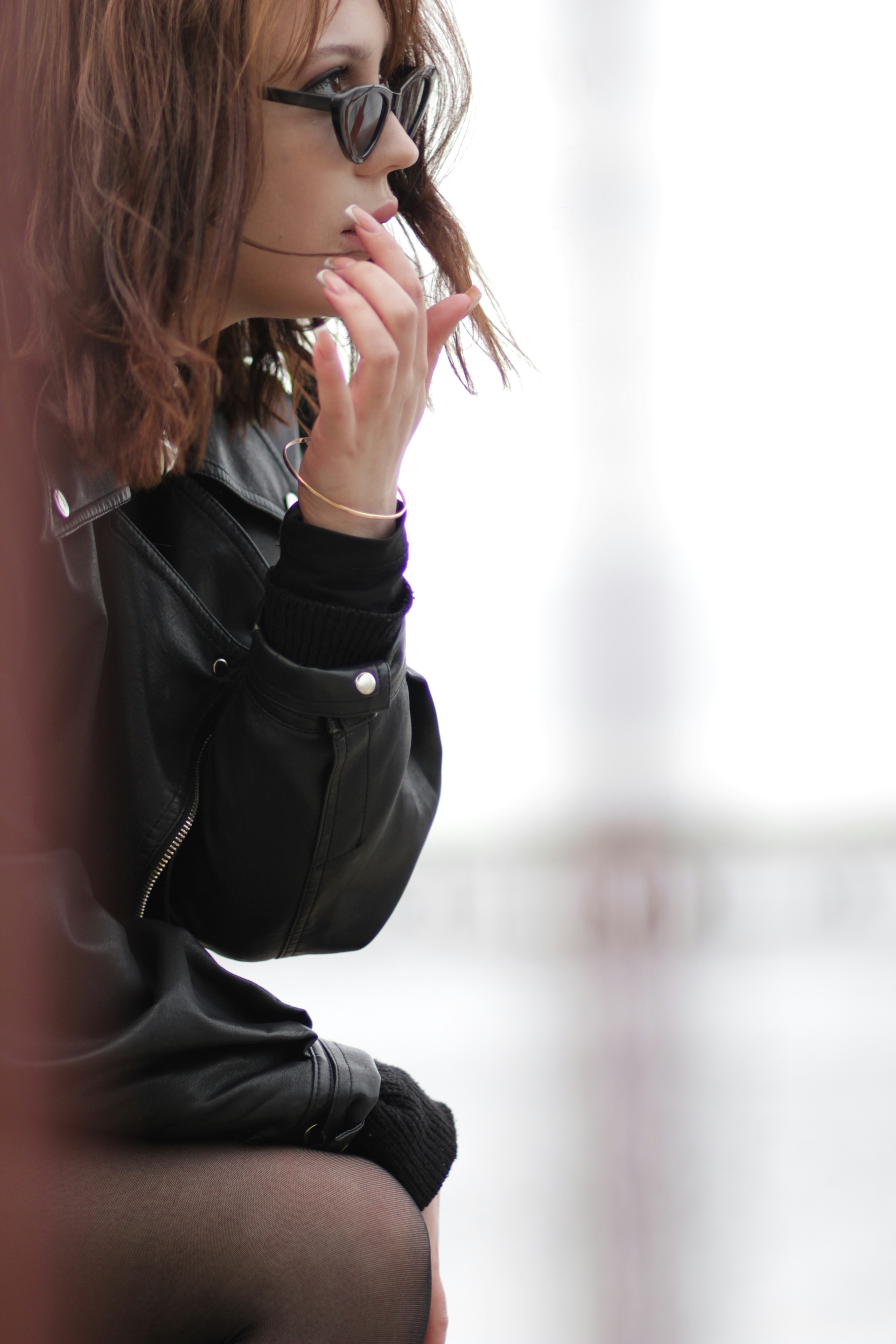 Junge Frau mit Sonnenbrille und Lederjacke