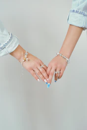 Two women holding hands with bracelets and bracelets