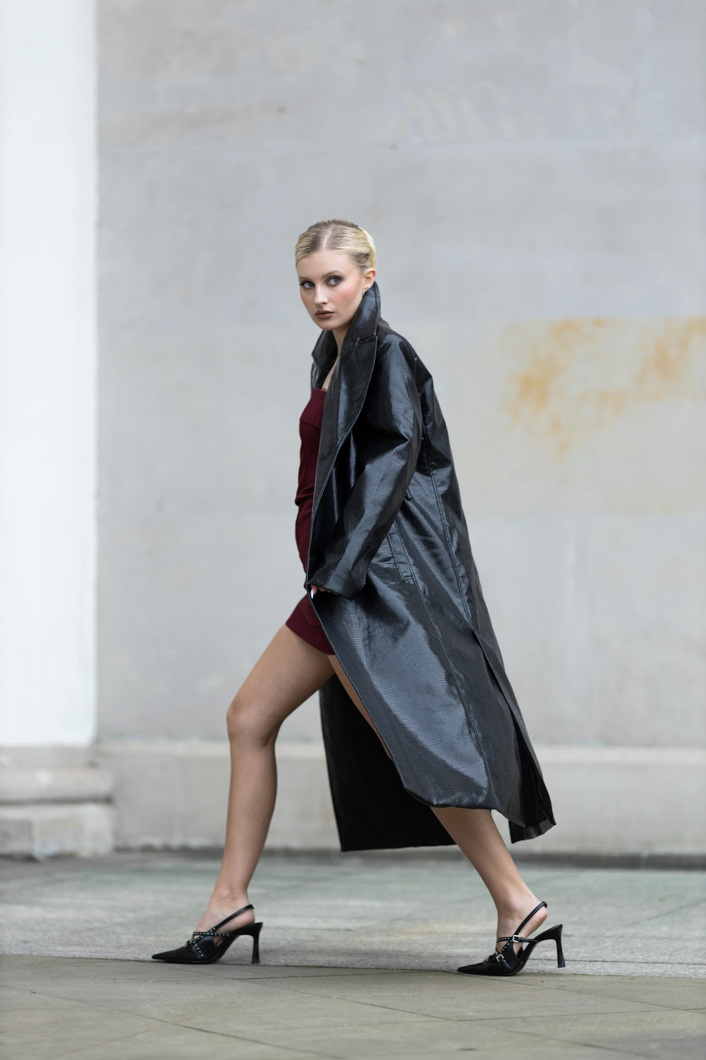 Black coat, walking past stone columns