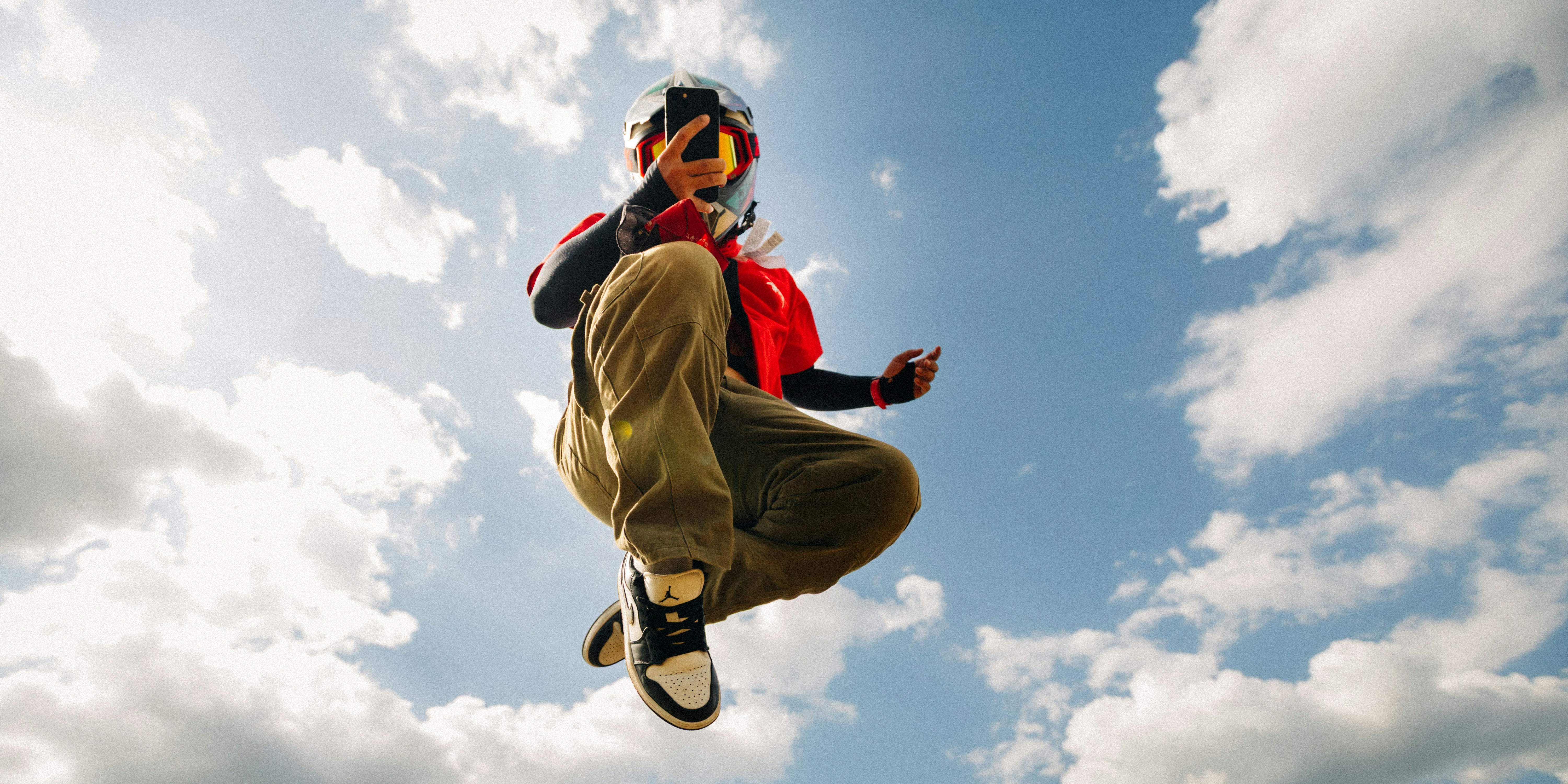 Person in mid-air against a cloudy sky