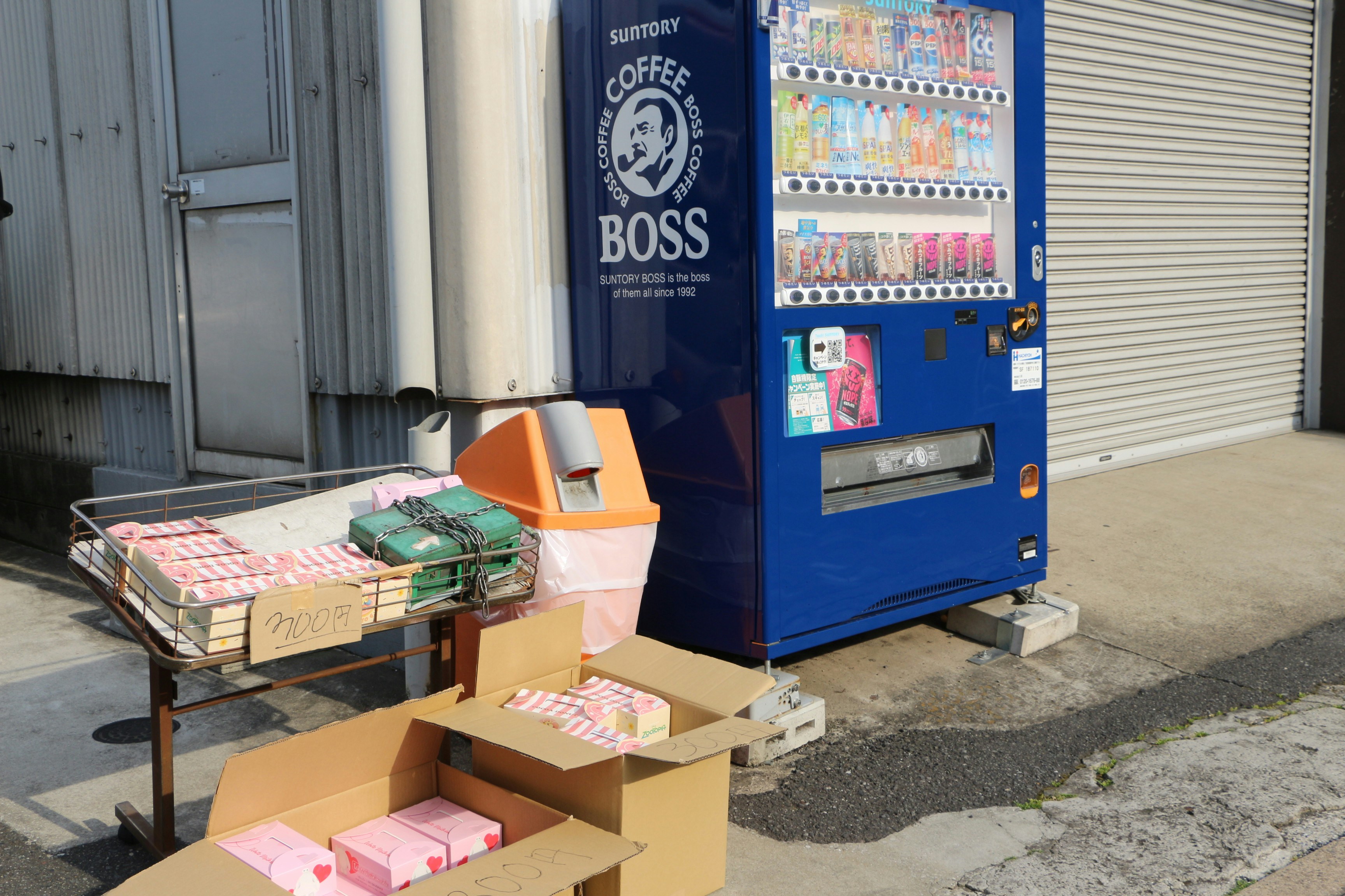 Coffee boss vending machine with stacked boxes of merchandise.