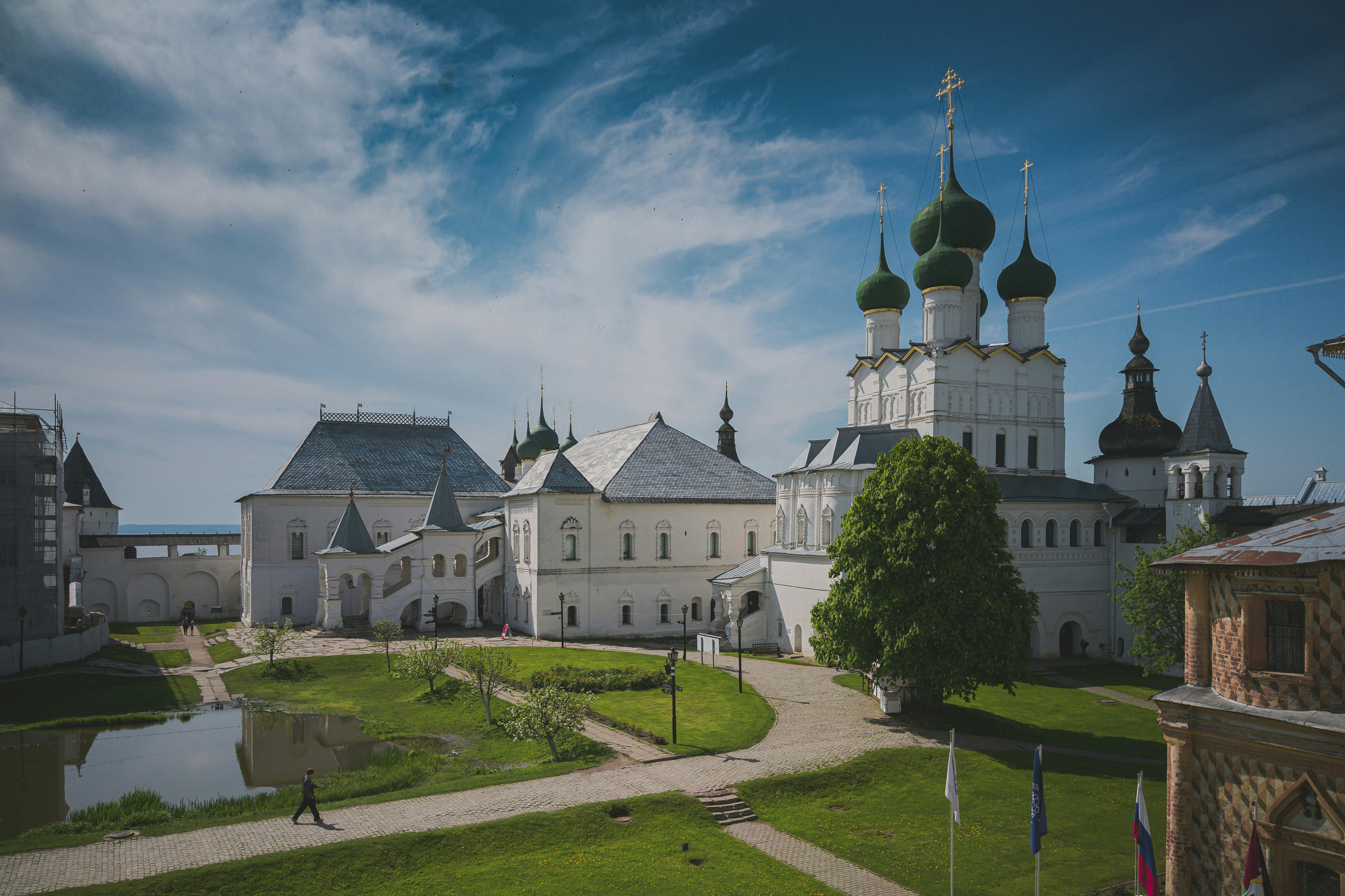 White monastery complex with green domes under blue sky