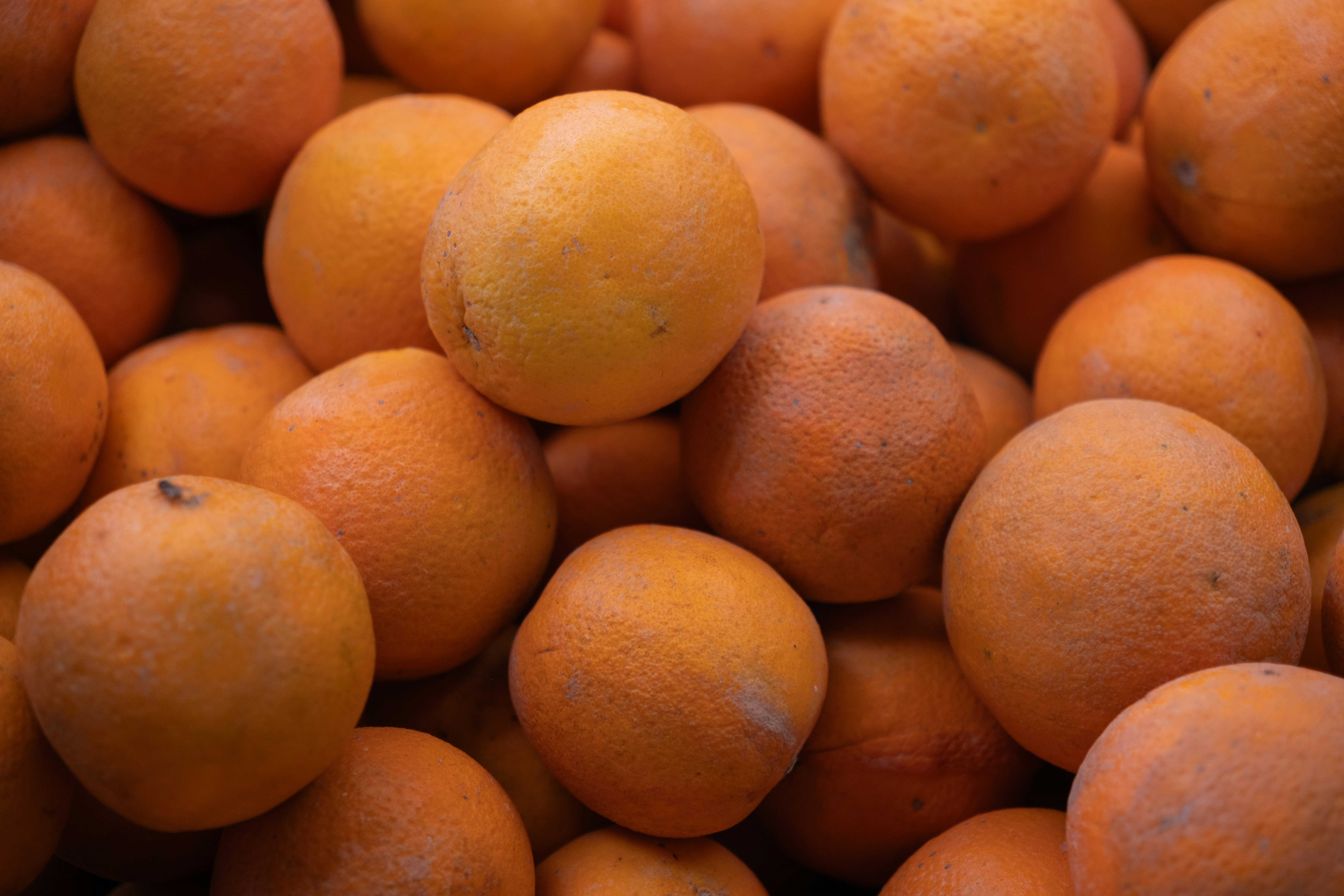 Many fresh, ripe oranges piled together