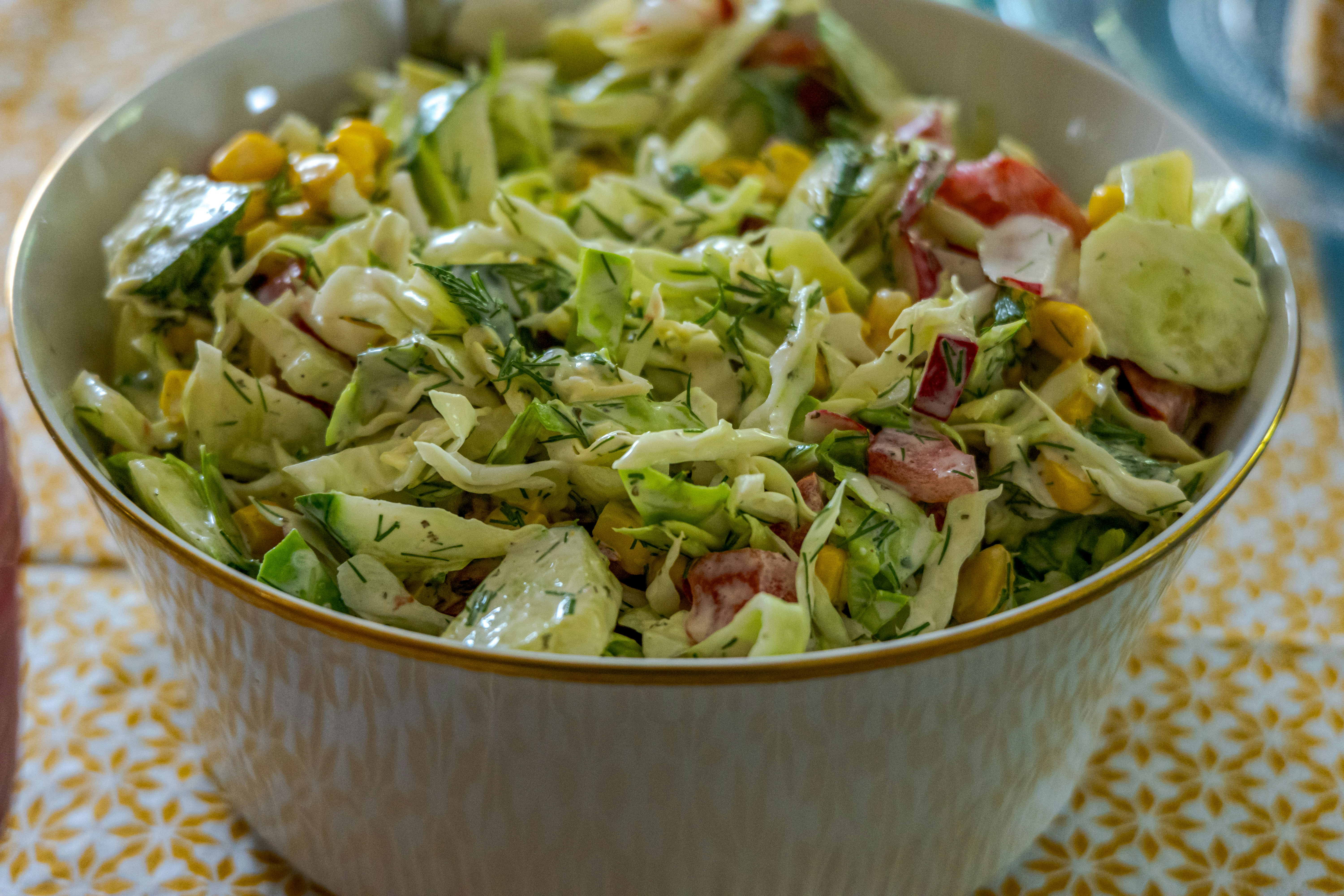 A bowl of fresh salad with vegetables and dressing