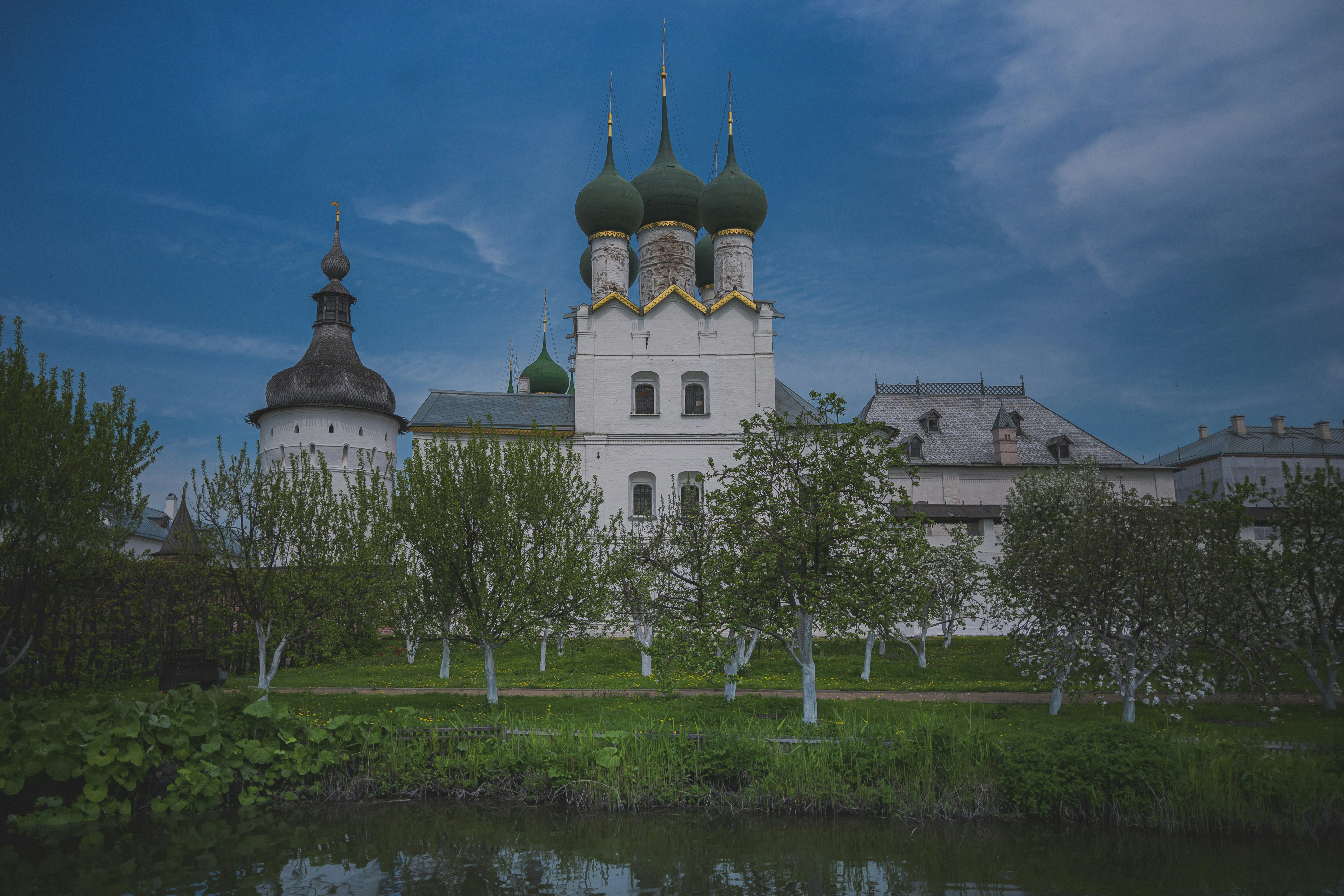 White church with green domes under blue sky.
