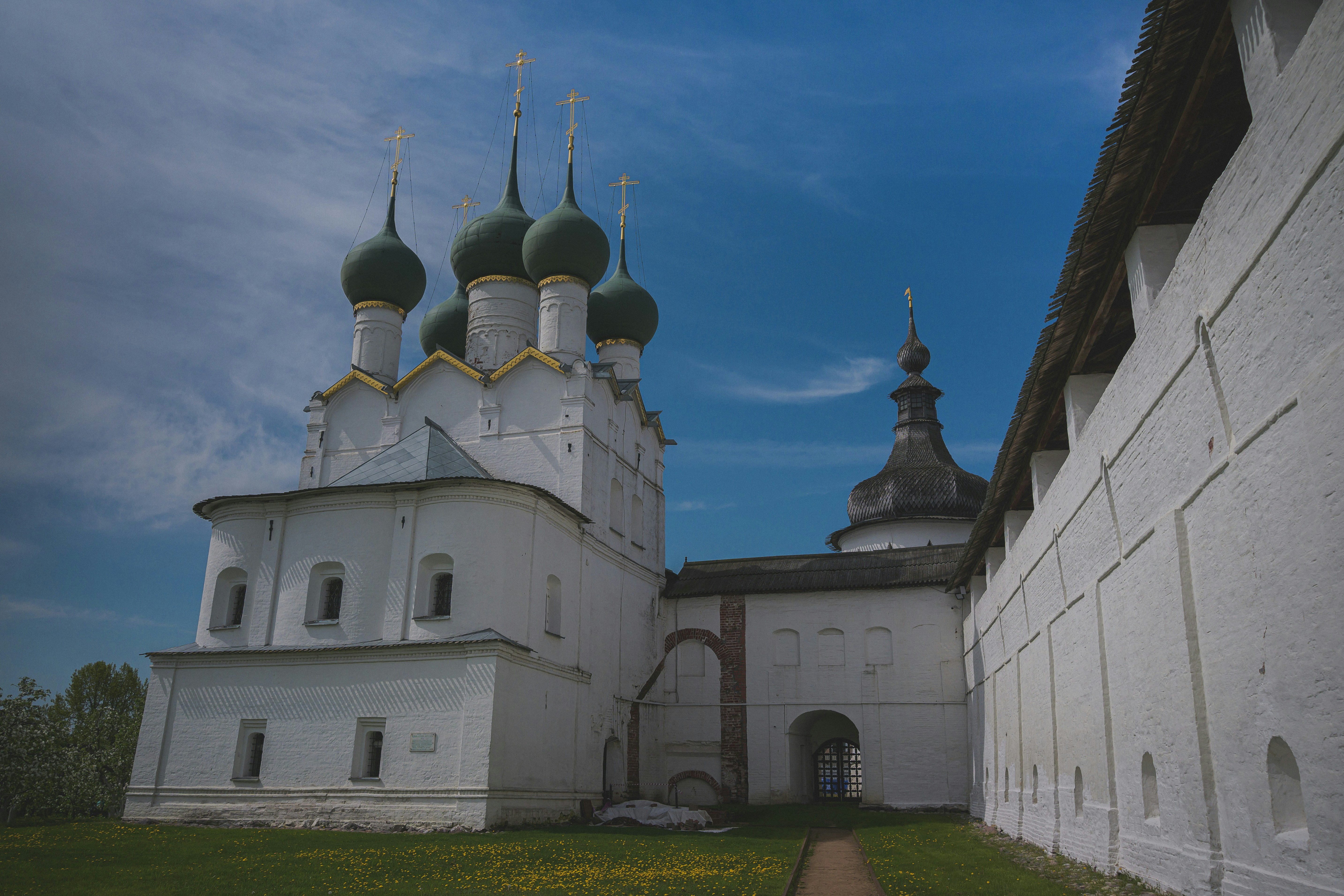 White church with green domes under blue sky.