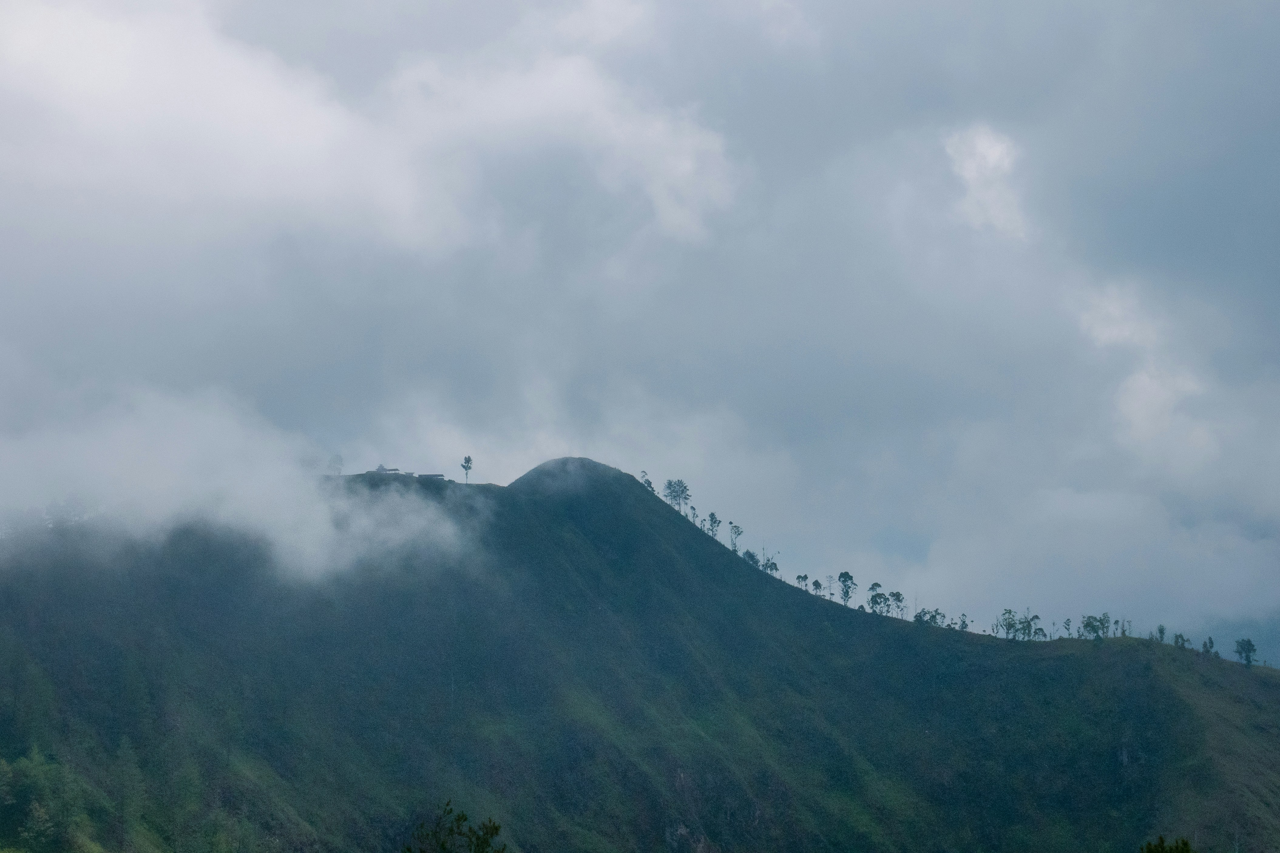A green mountain peak shrouded in mist, like the Iao Needle