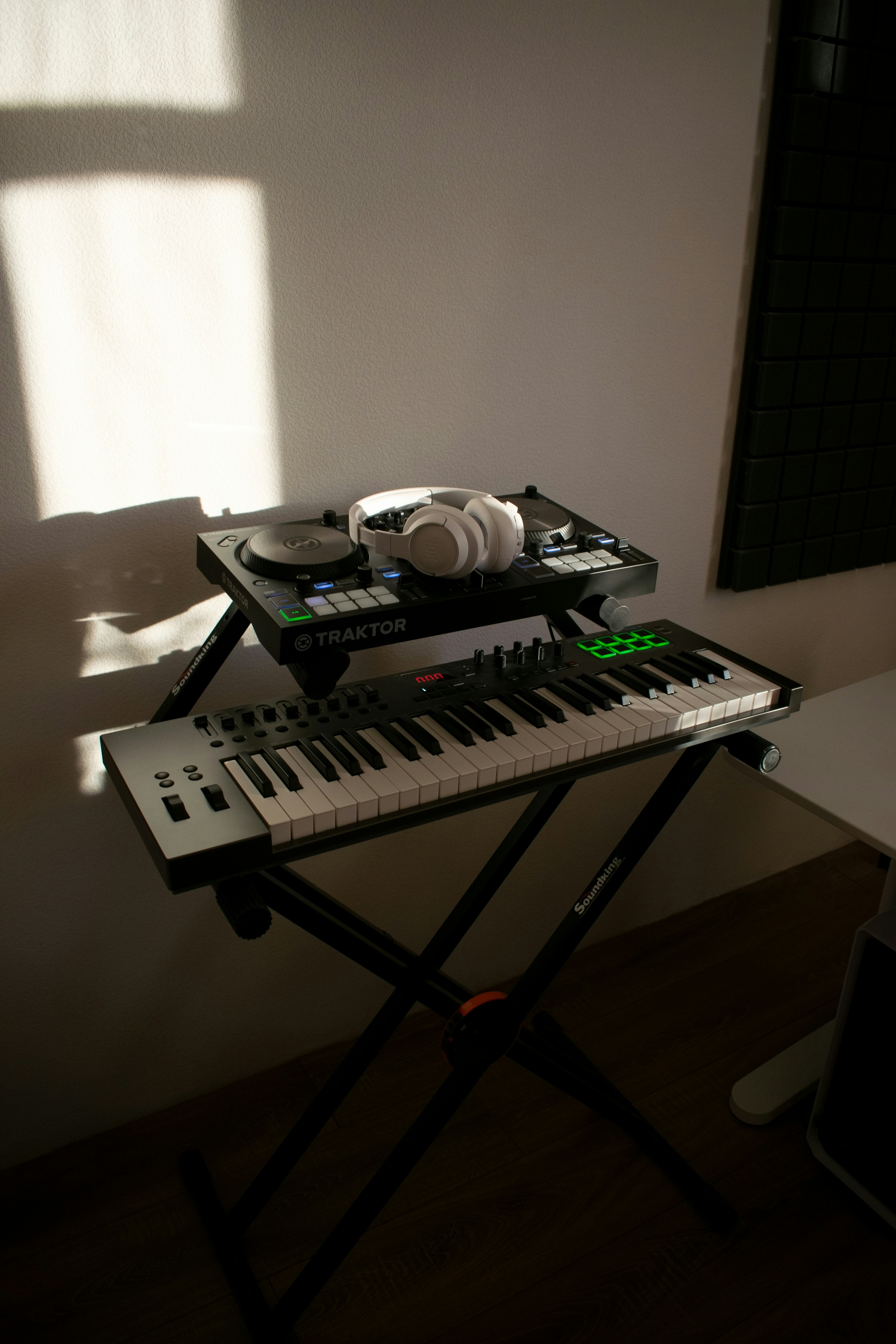 Dj equipment and keyboard with headphones on a stand.