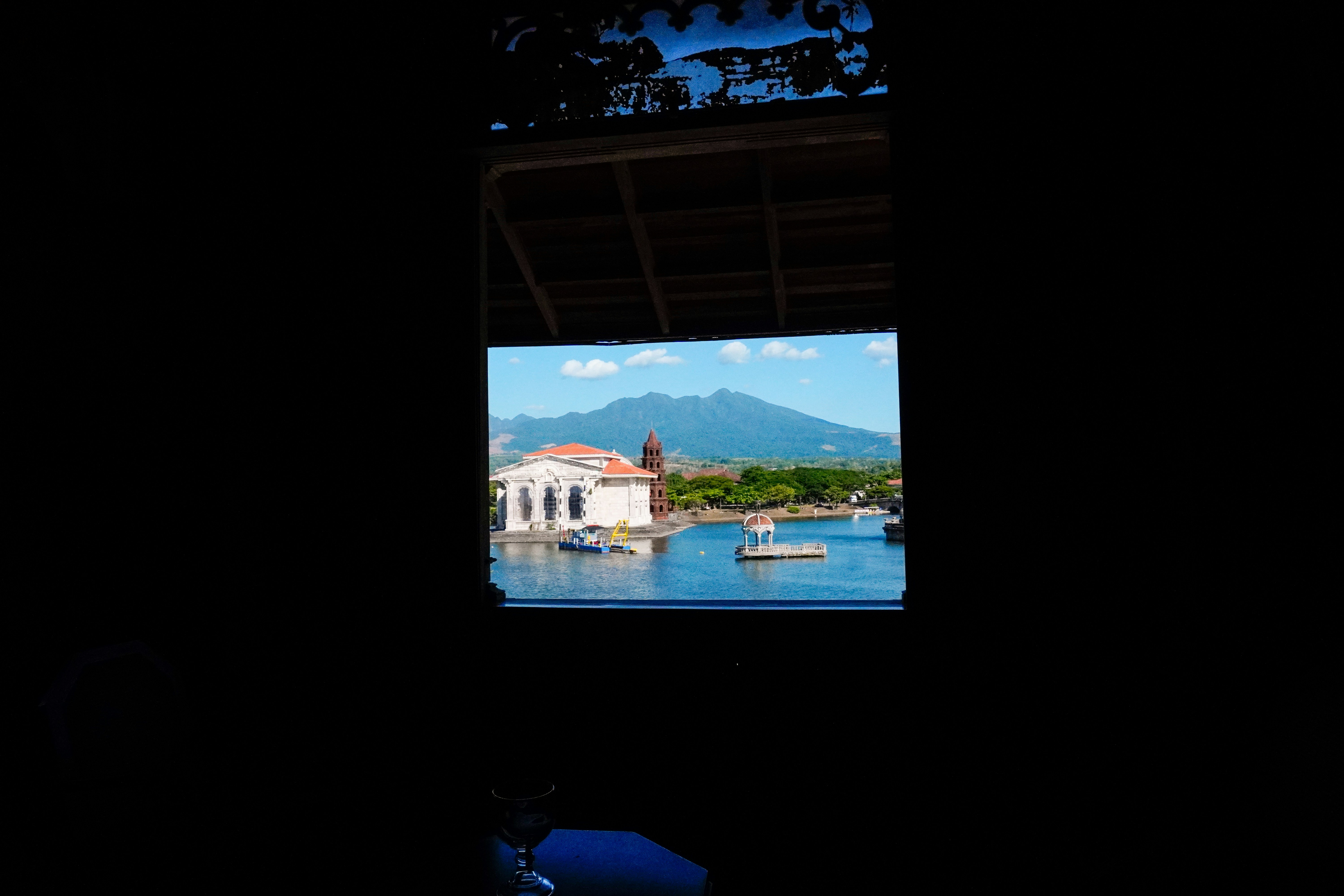 A building on water with mountains in the background. photo – Free ...