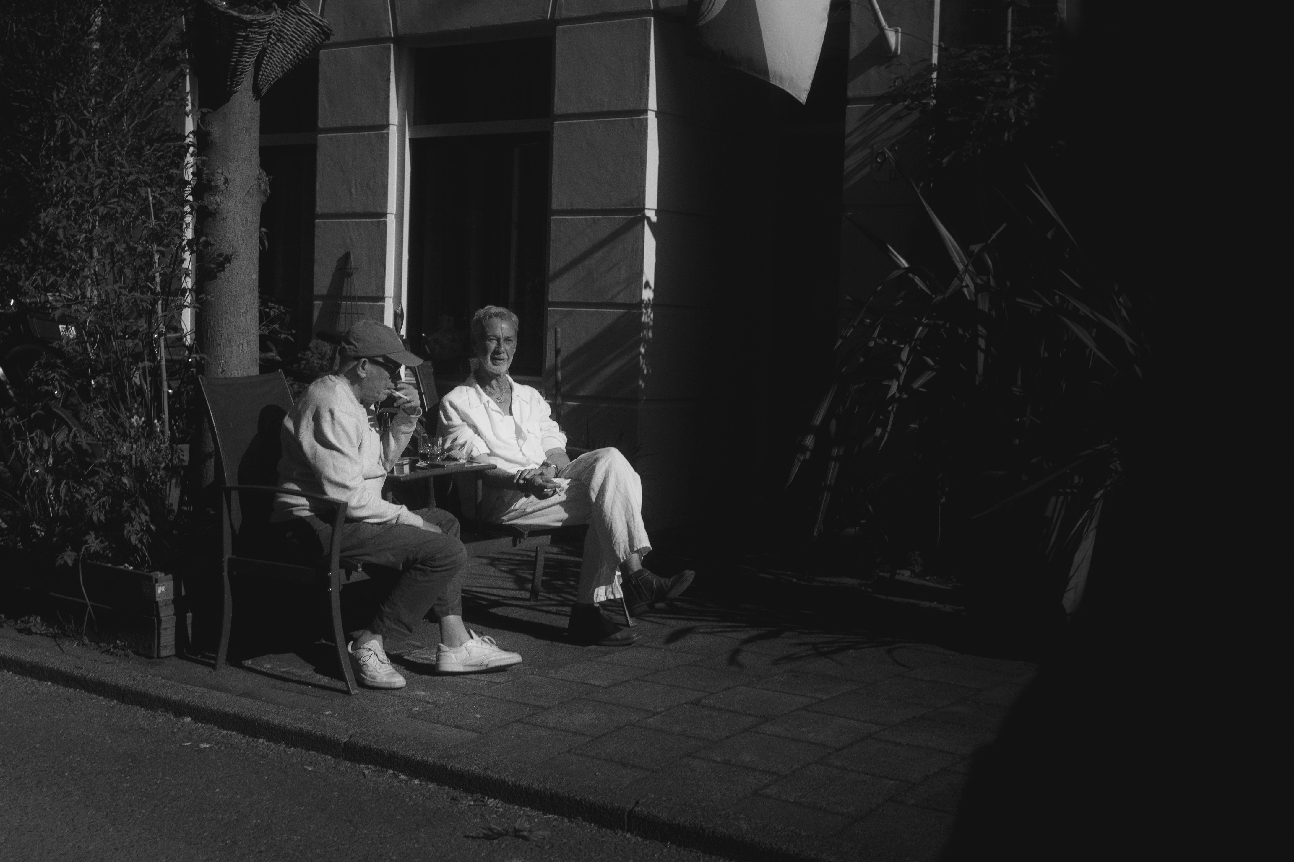 Two people sitting on a bench outdoors at night.