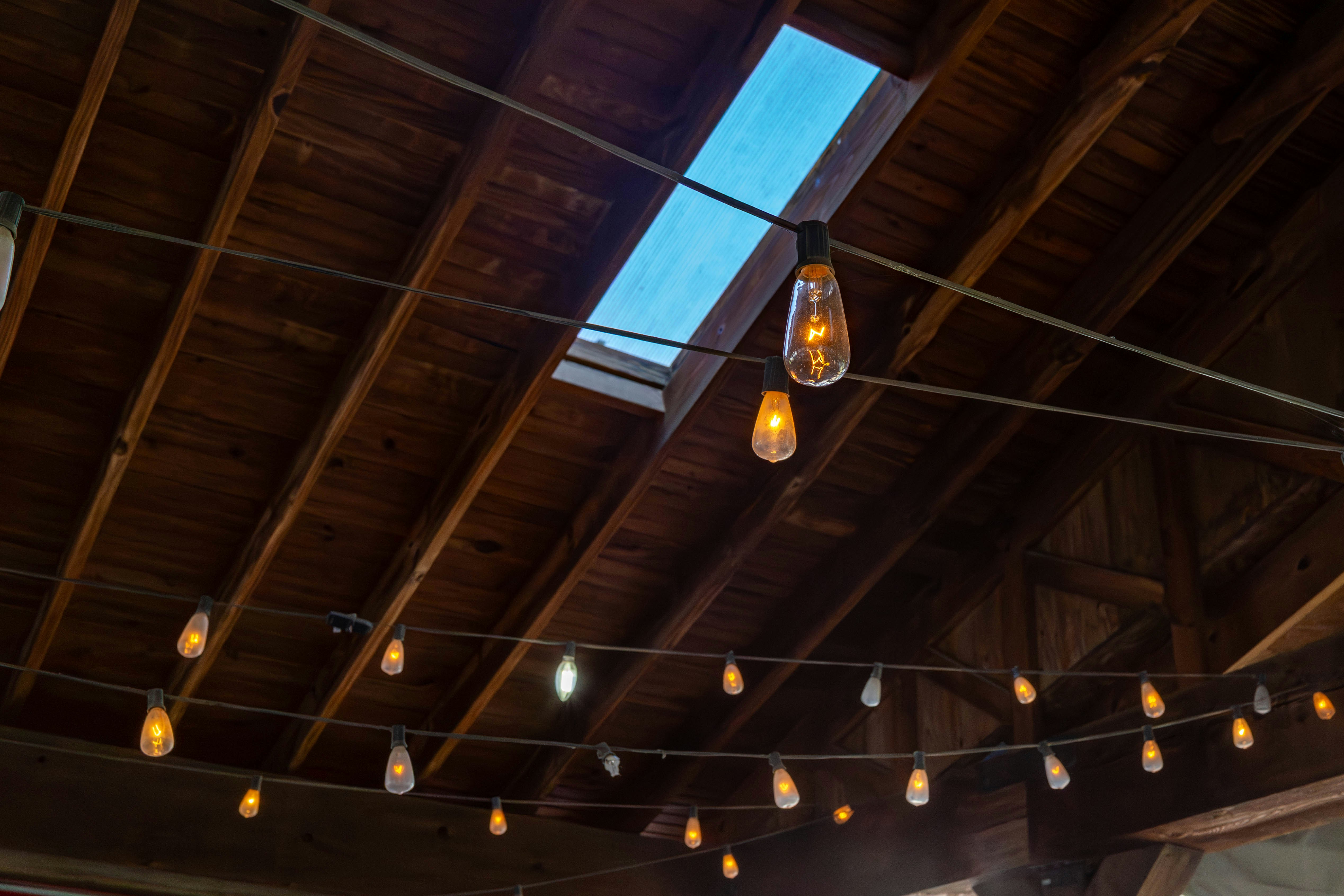Lichterketten beleuchten eine Holzdecke mit einem Oberlicht.