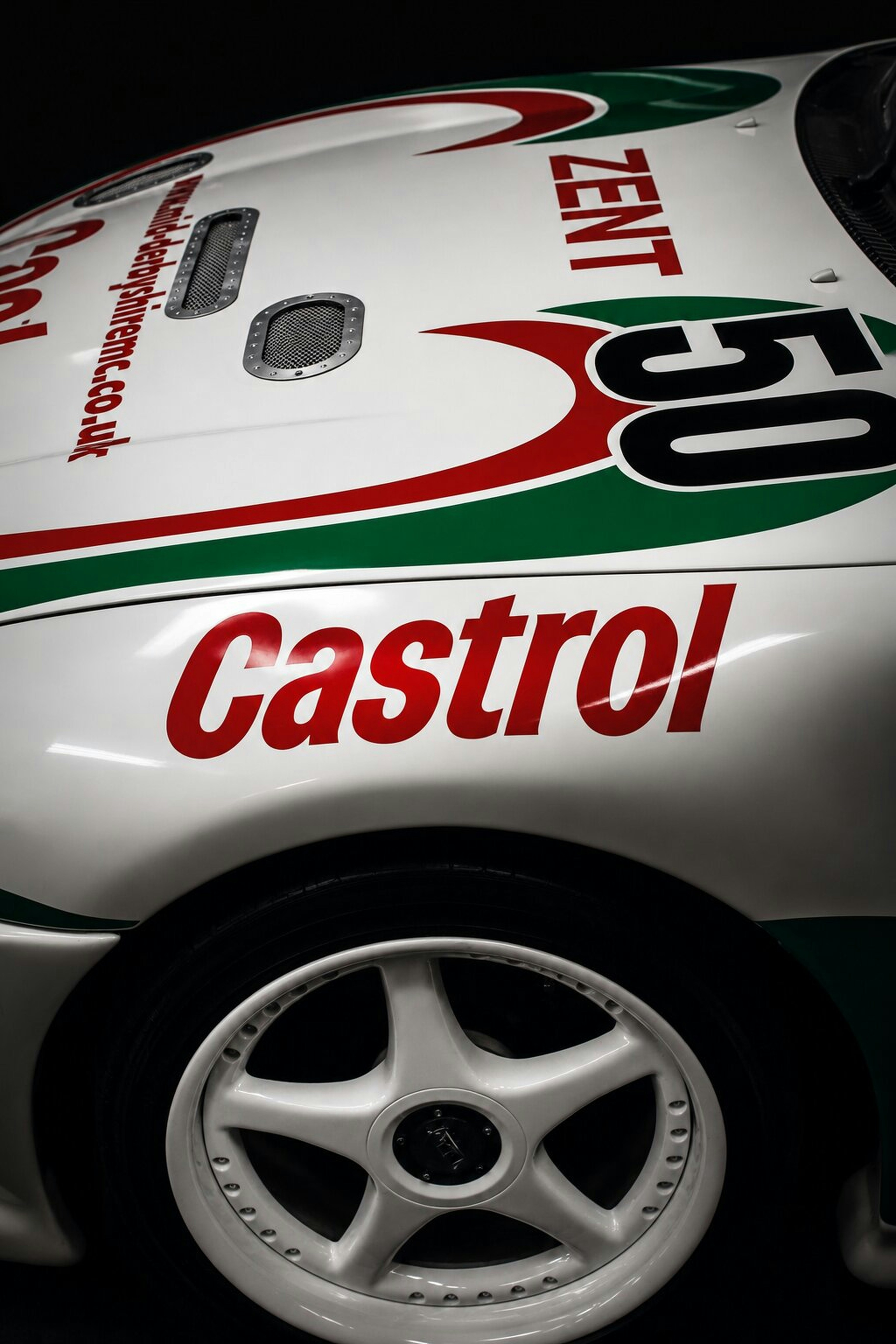 Coche de carreras blanco con logotipos de castrol y zent.